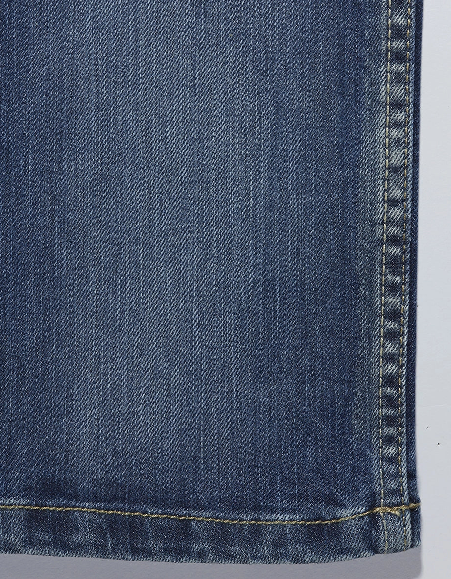 Jeansstoff in Blau, Detailaufnahme, ohne Muster, mit gelber Naht.