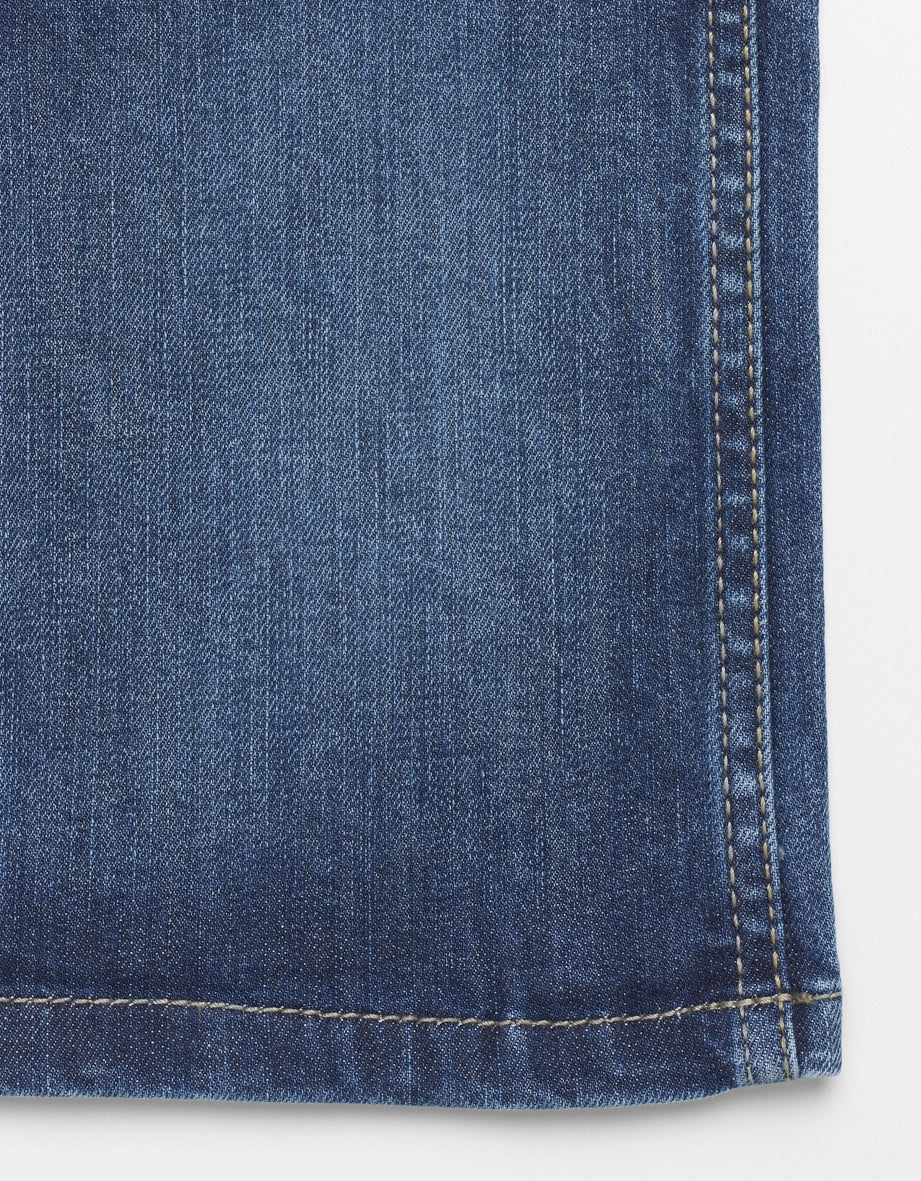 Nahaufnahme eines blauen bugatti Jeansstoffs mit feiner Textur und detailreicher Naht.