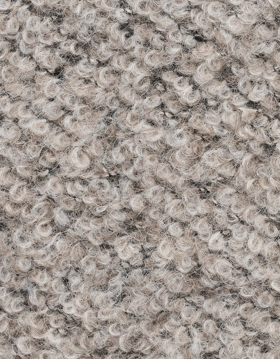 Close-up of beige bouclé fabric with textured surface.