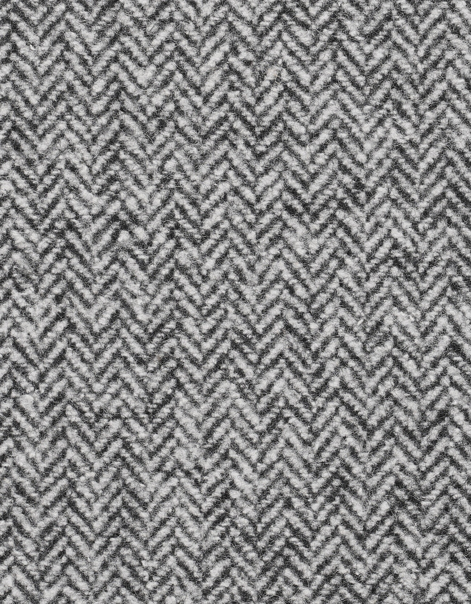 Graue Fischgrät-Weste mit schwarzem Rollkragenpullover, Modelbild, entspannter Gesichtsausdruck.