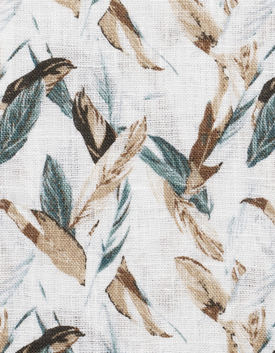 Linnen stof met beige en groen bladpatroon, close-up.