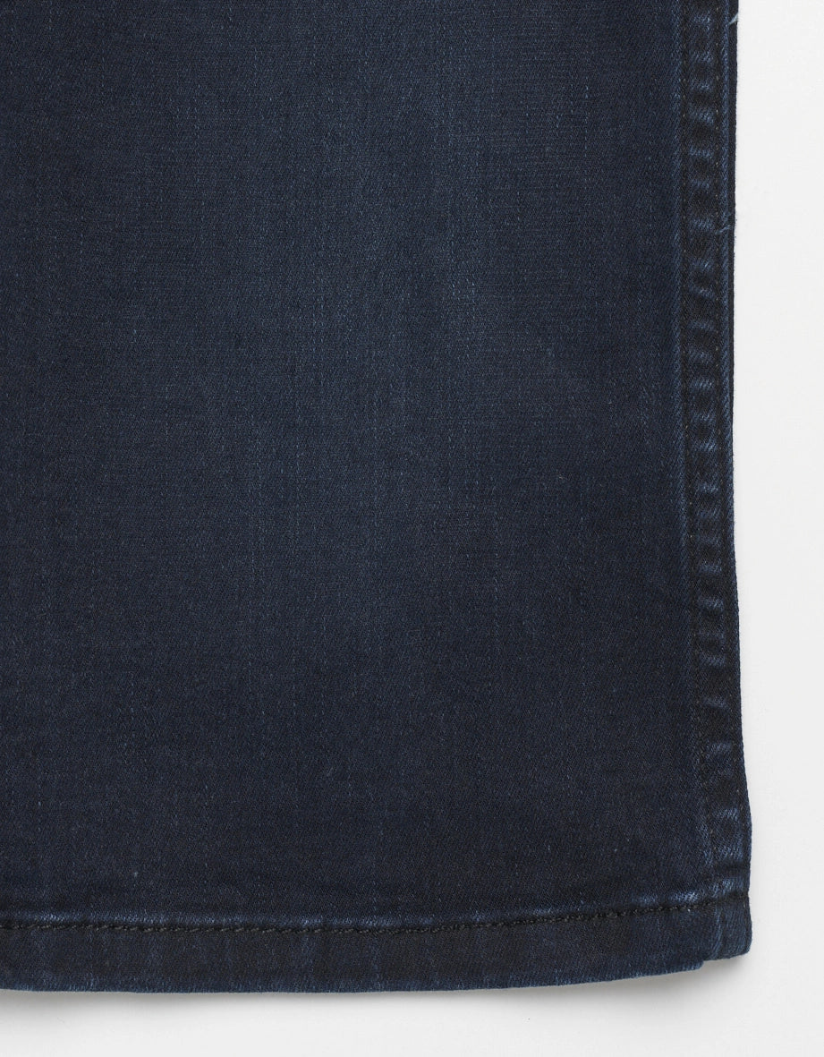 Dark blue denim texture by bugatti, close-up detail.