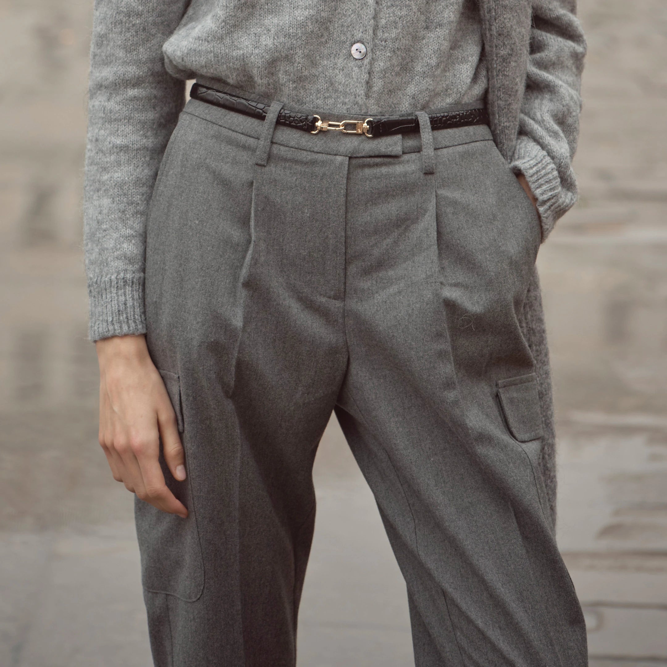 Nahaufnahme einer grauen bugatti Damenhose mit Bundfalten und seitlichen Taschen, kombiniert mit schmalem Gürtel – moderner Business-Casual Look der Herbst/Winter-Kollektion 2025 im Venetian Chic.