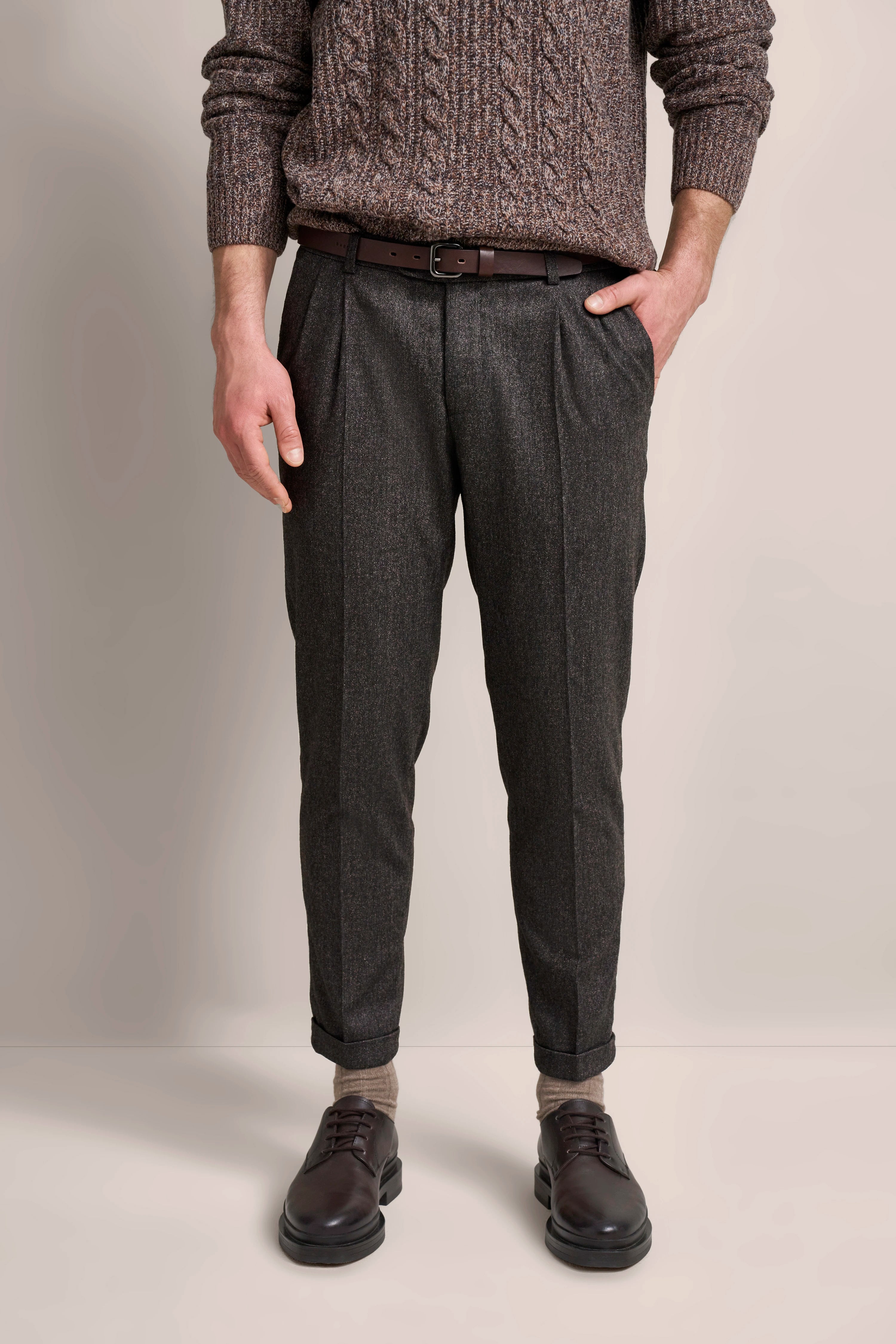 Brauner Zopfpullover und graue Anzughose, legeres Büstenbild, bugatti.