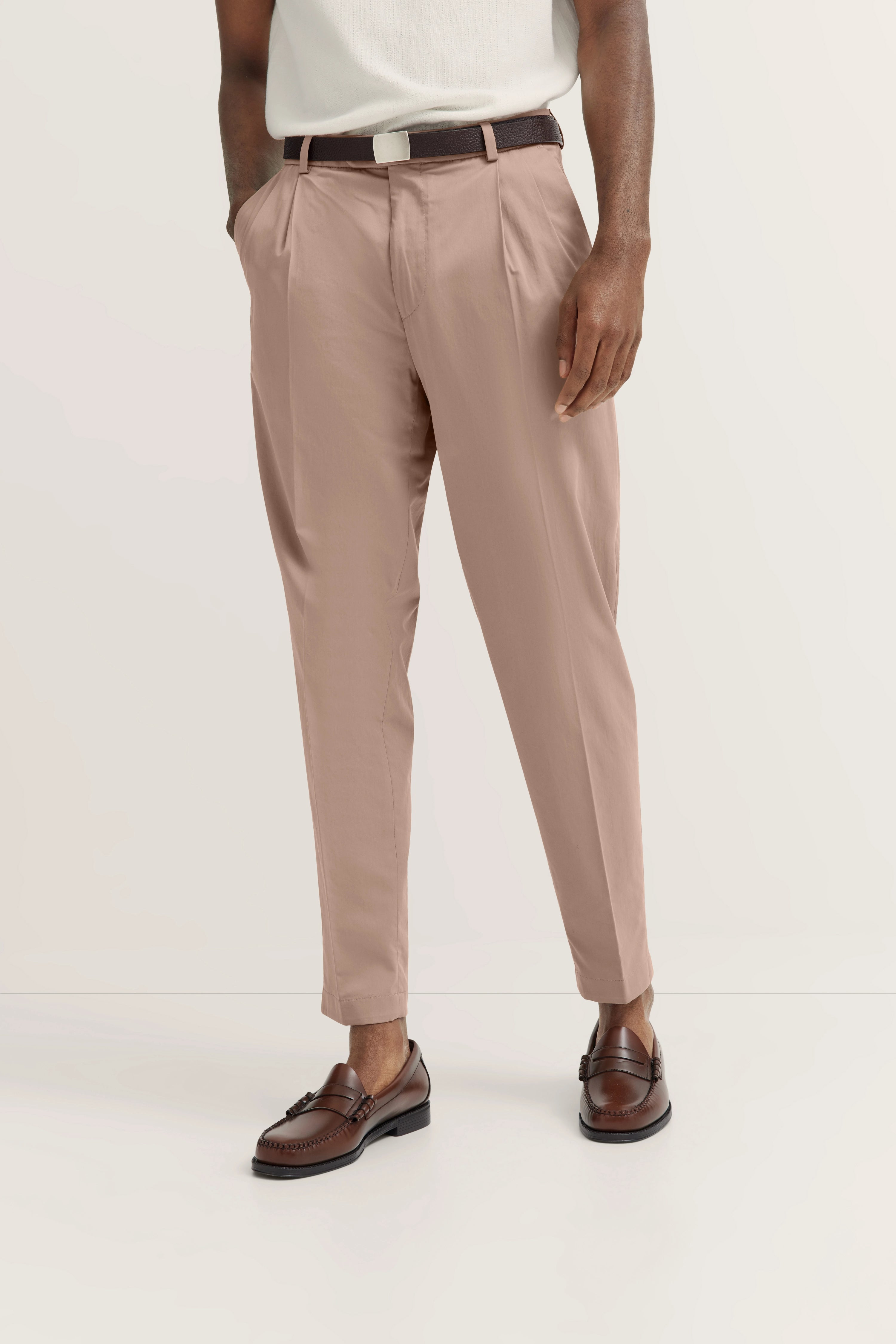 Hose in Beige von bugatti, kombiniert mit weißem Oberteil und braunen Loafers, legeres Modelbild.