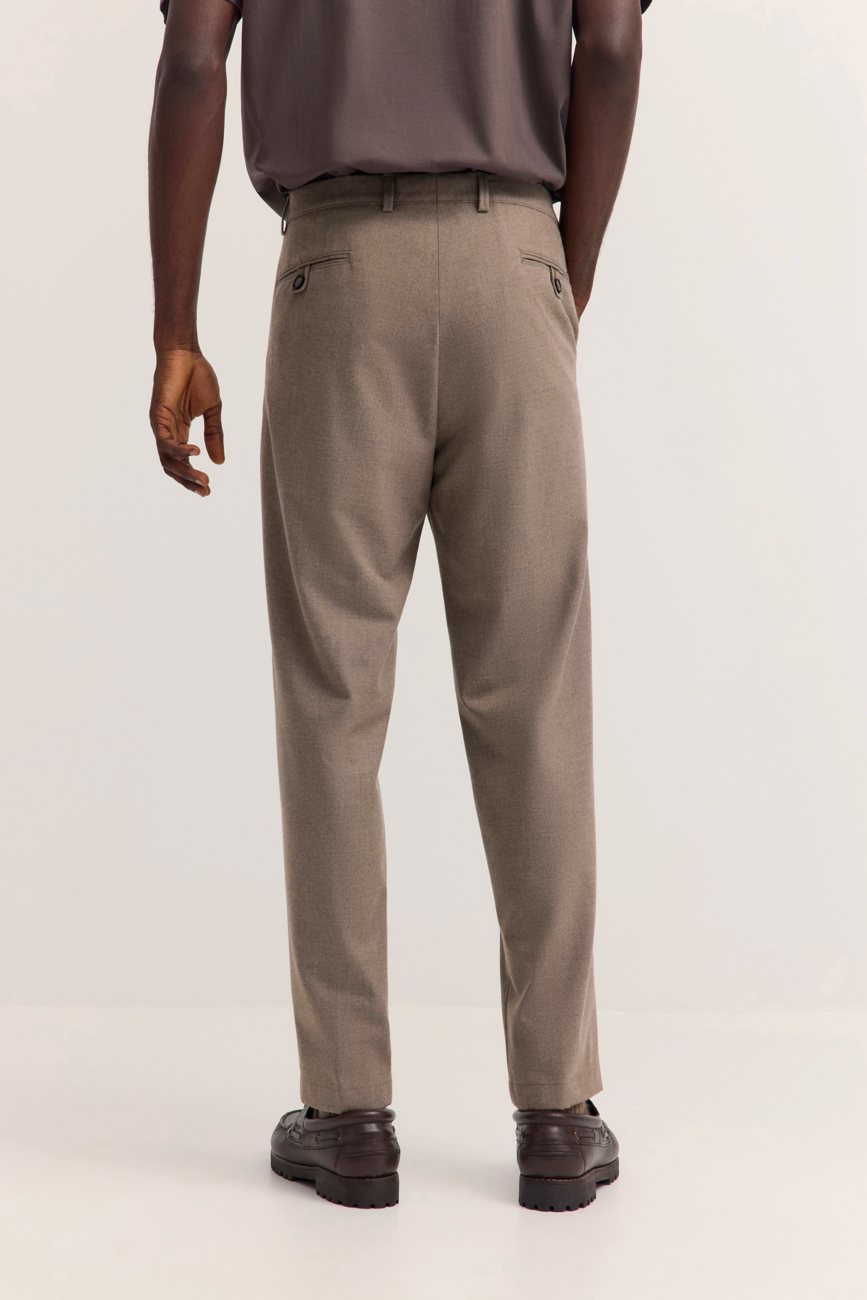Beige bugatti Chinohose, legeres Modelbild, Rückansicht, kombiniert mit braunen Schuhen.