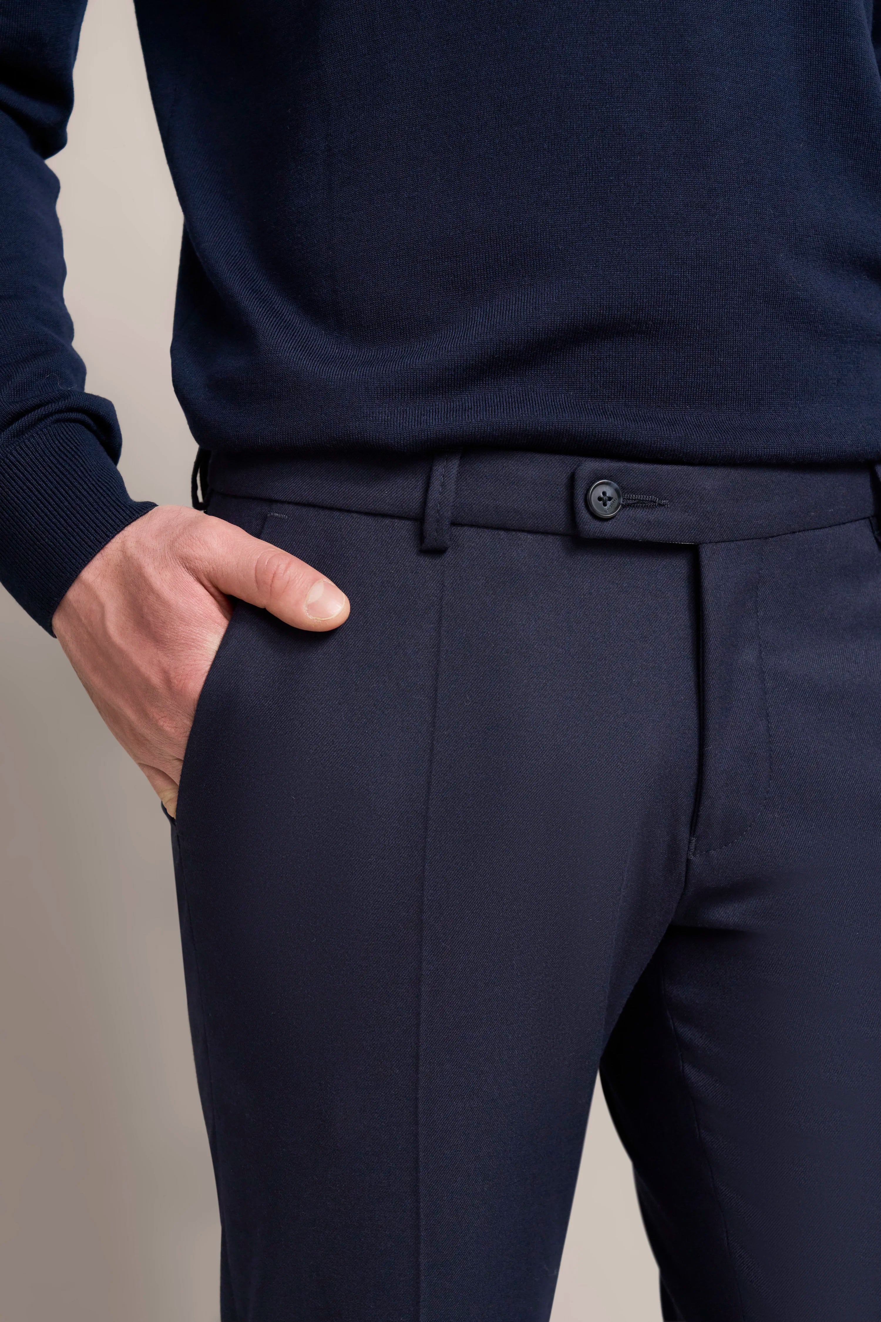 Dark blue men's suit with hand in pocket, bust shot, bugatti style.