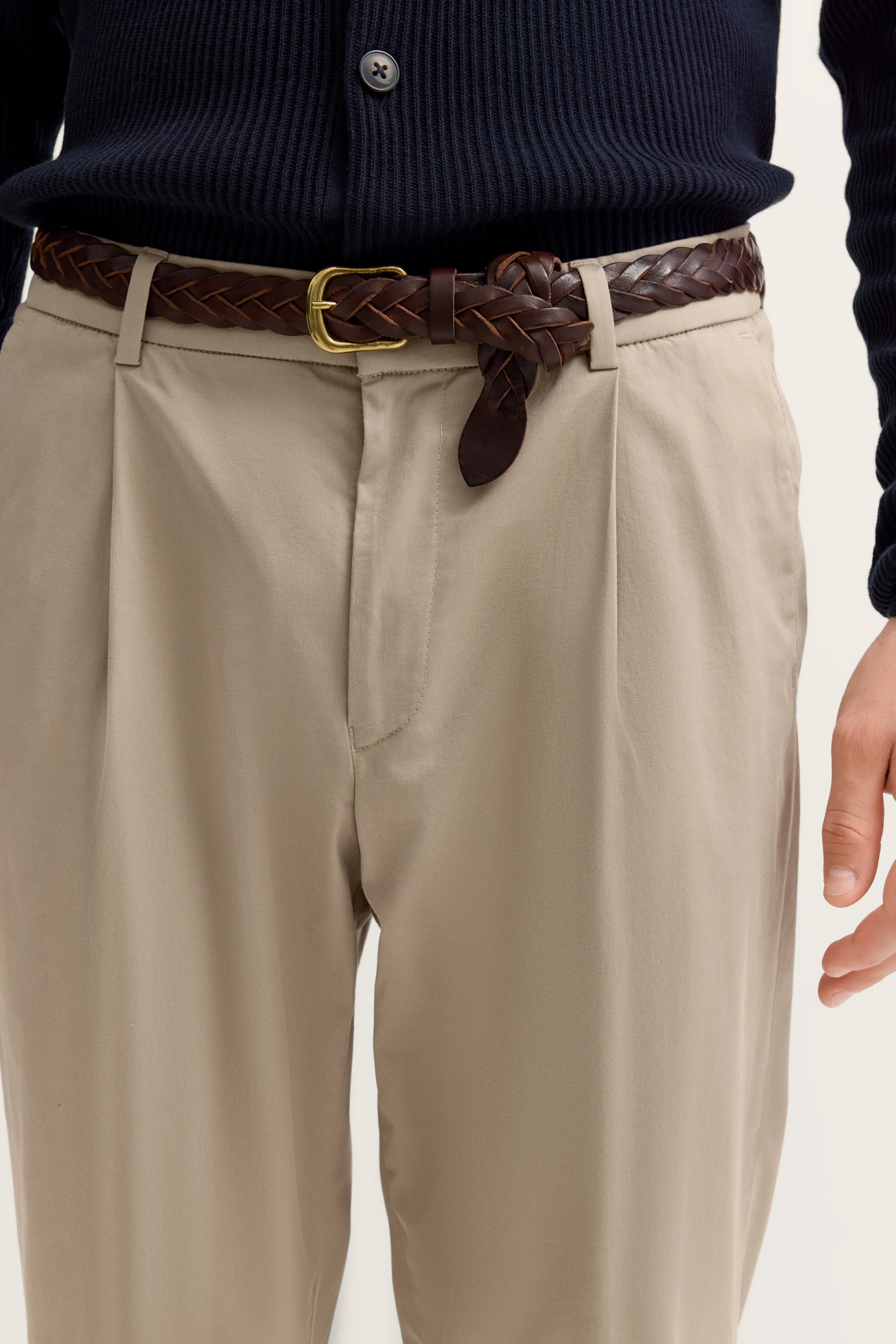 Beiger Chino und dunkelblauer Pullover von bugatti, Detailaufnahme mit geflochtenem braunem Gürtel.