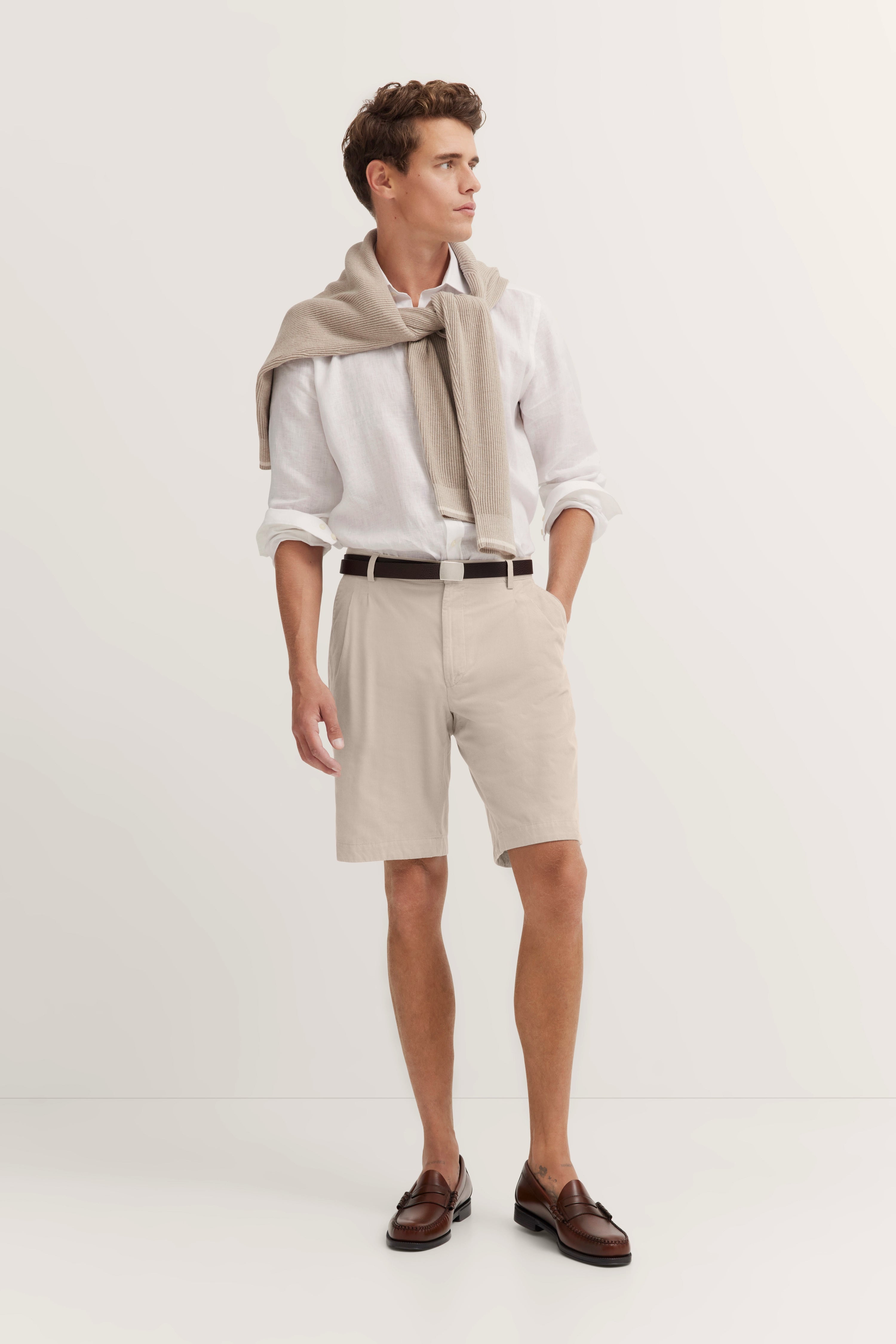 Beige shorts with white shirt, casual back view, brown shoes, bugatti style.