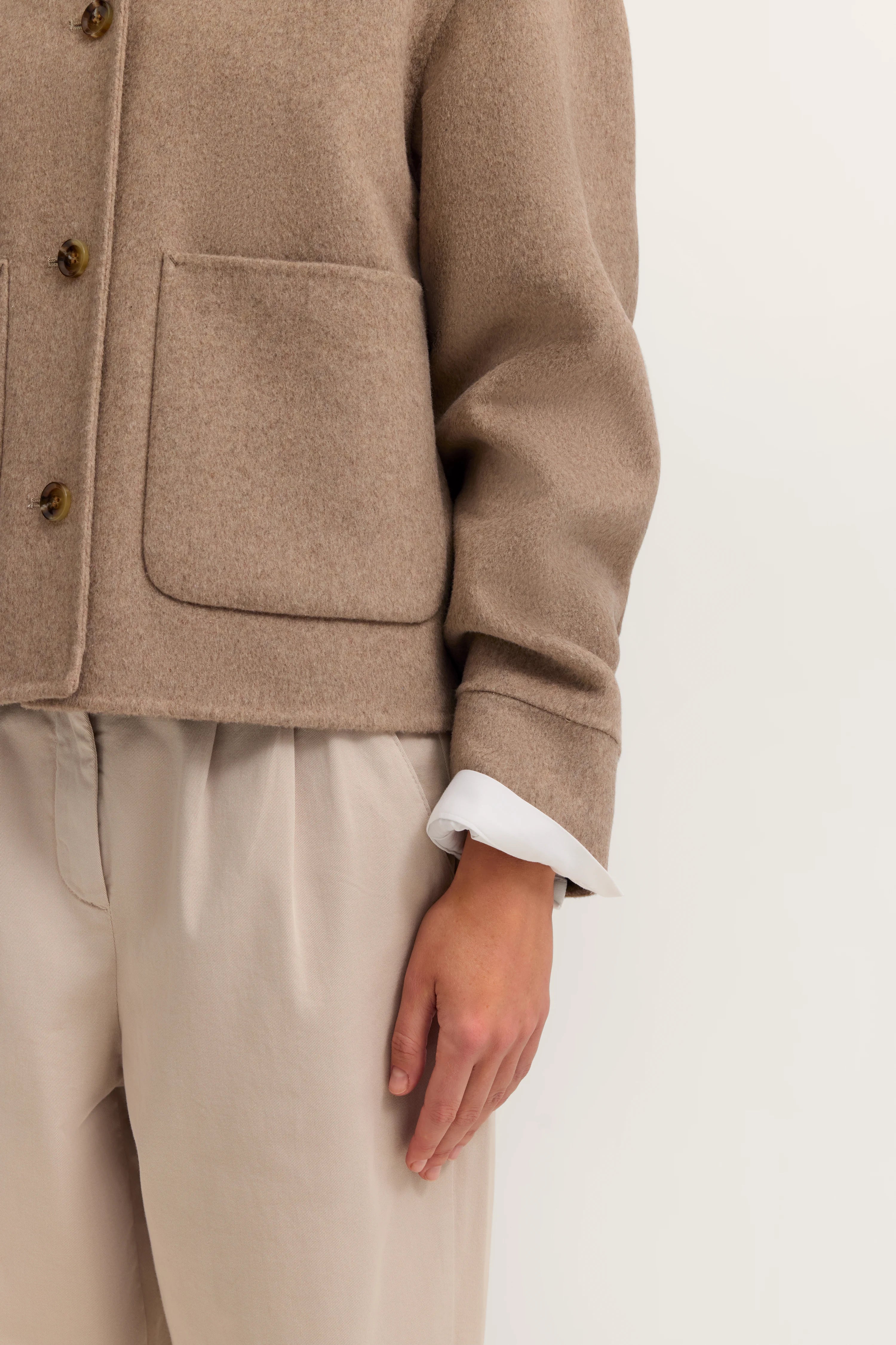 Beiger bugatti Mantel und helle Hose, legeres Büstenbild.