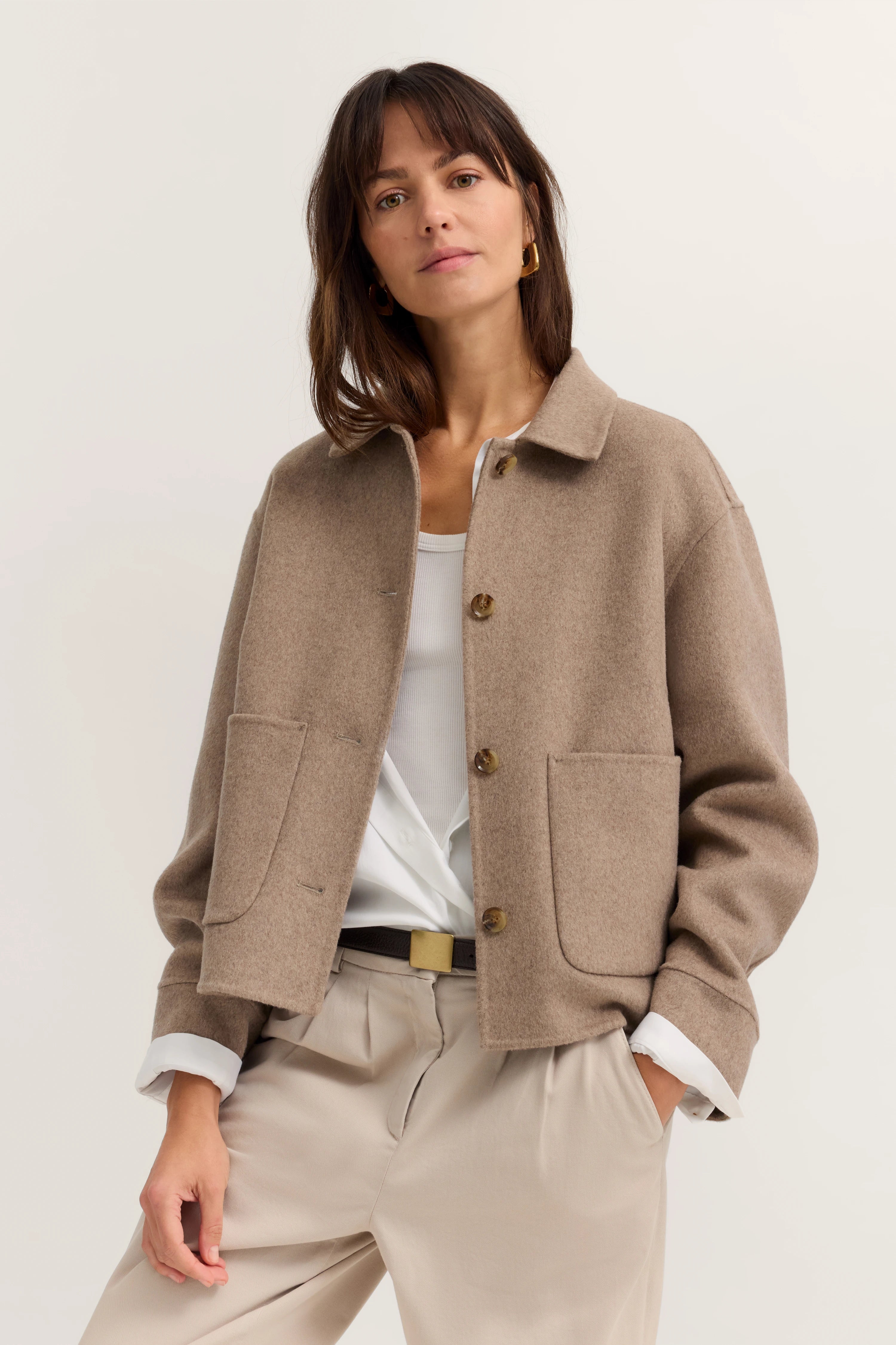 Beige Jacke mit weißen und beigen Tönen, Modelbild, entspannte Pose.