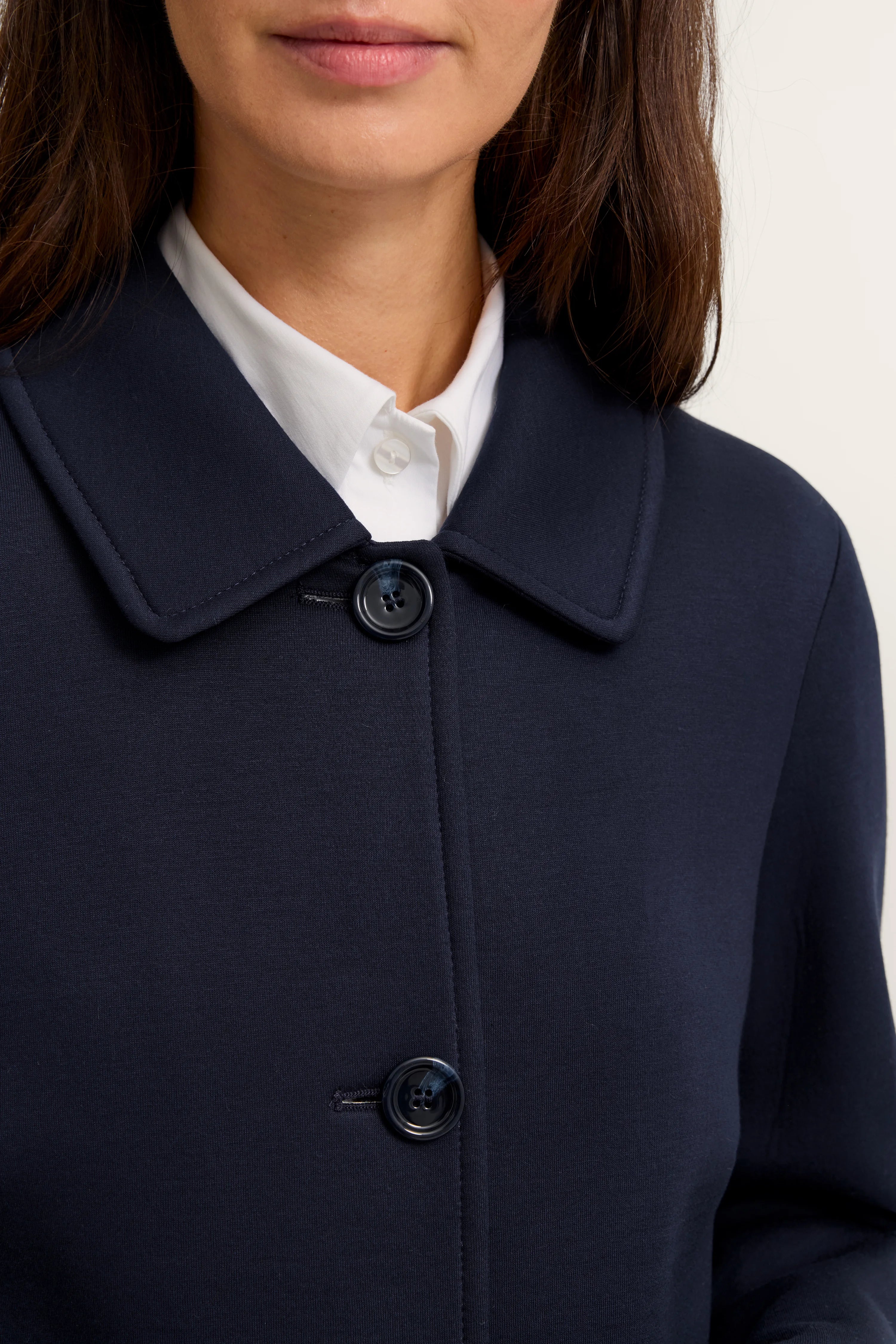 Dunkelblauer bugatti Mantel auf Büste, weißes Hemd, eleganter Stil.