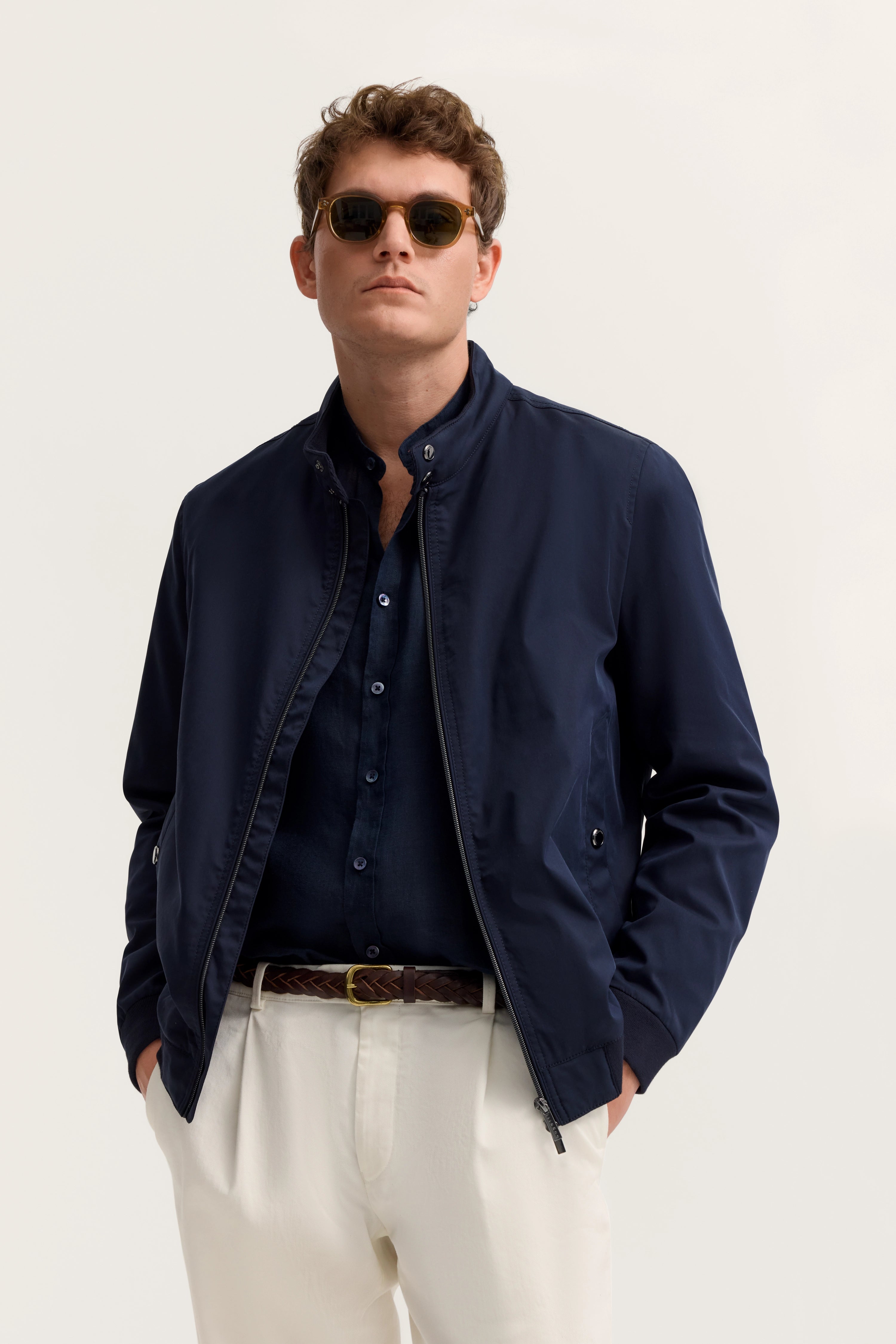 Elegantes Model in navy Blouson, dunklem Hemd, weißer Hose