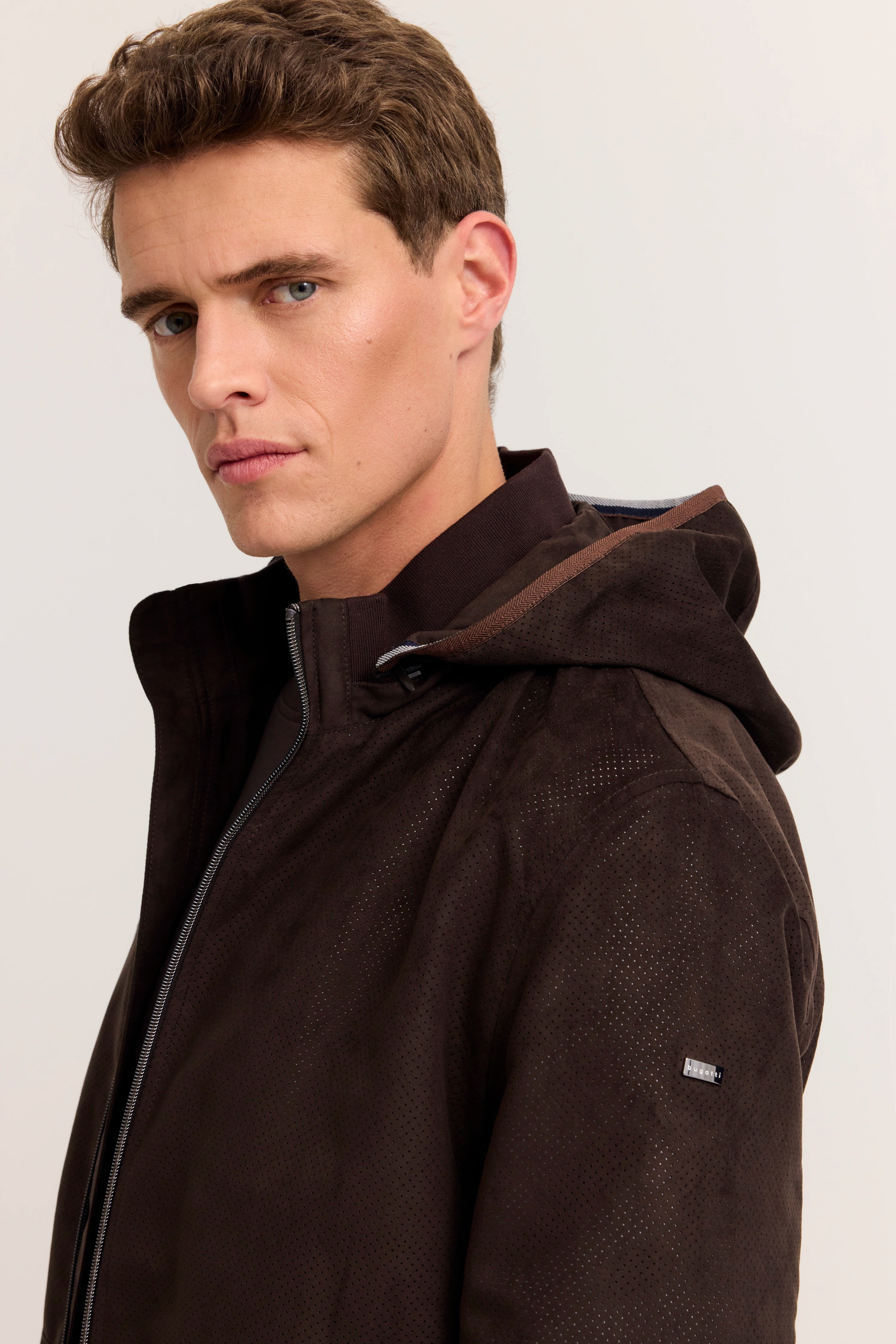 Dunkle Kapuzenjacke von bugatti, Rückansicht auf Model, kombiniert mit beigen Hosen.