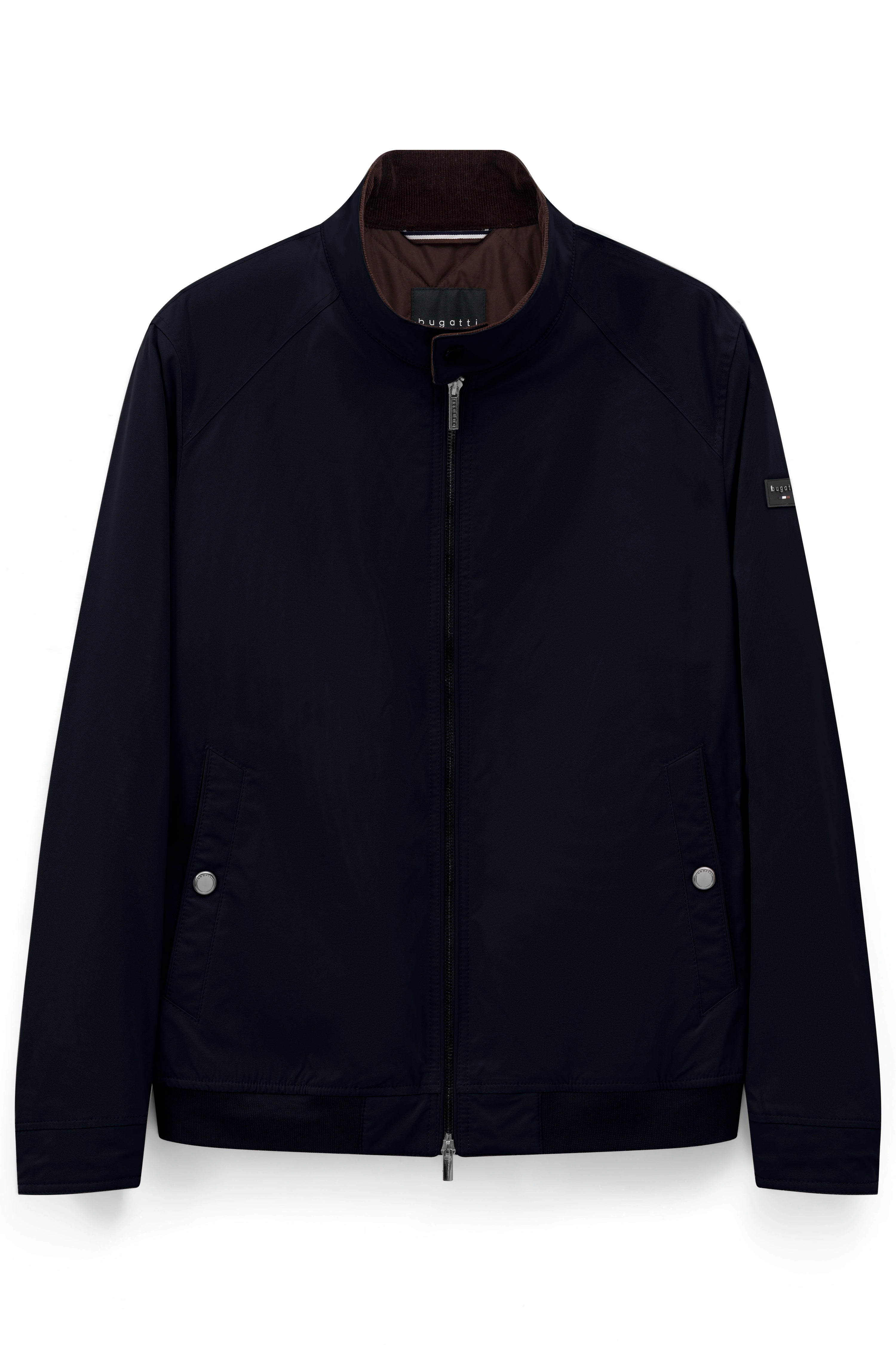 bugatti Model mit dunkelblauer Jacke, gestreiftem Hemd, beiger Hose. Leger stehende Pose.