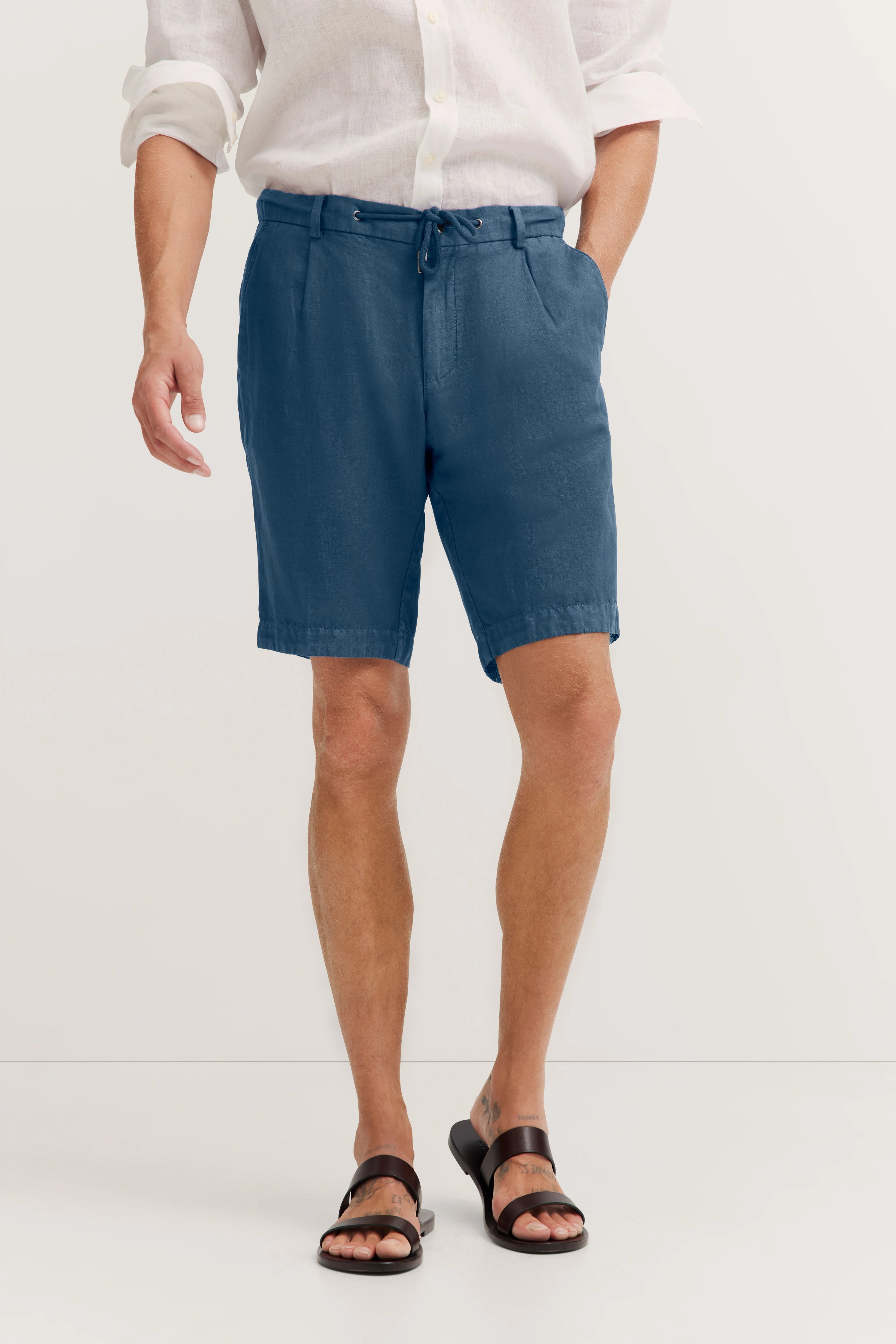 Weiße Leinenhemd, blaue Shorts, braune Sandalen