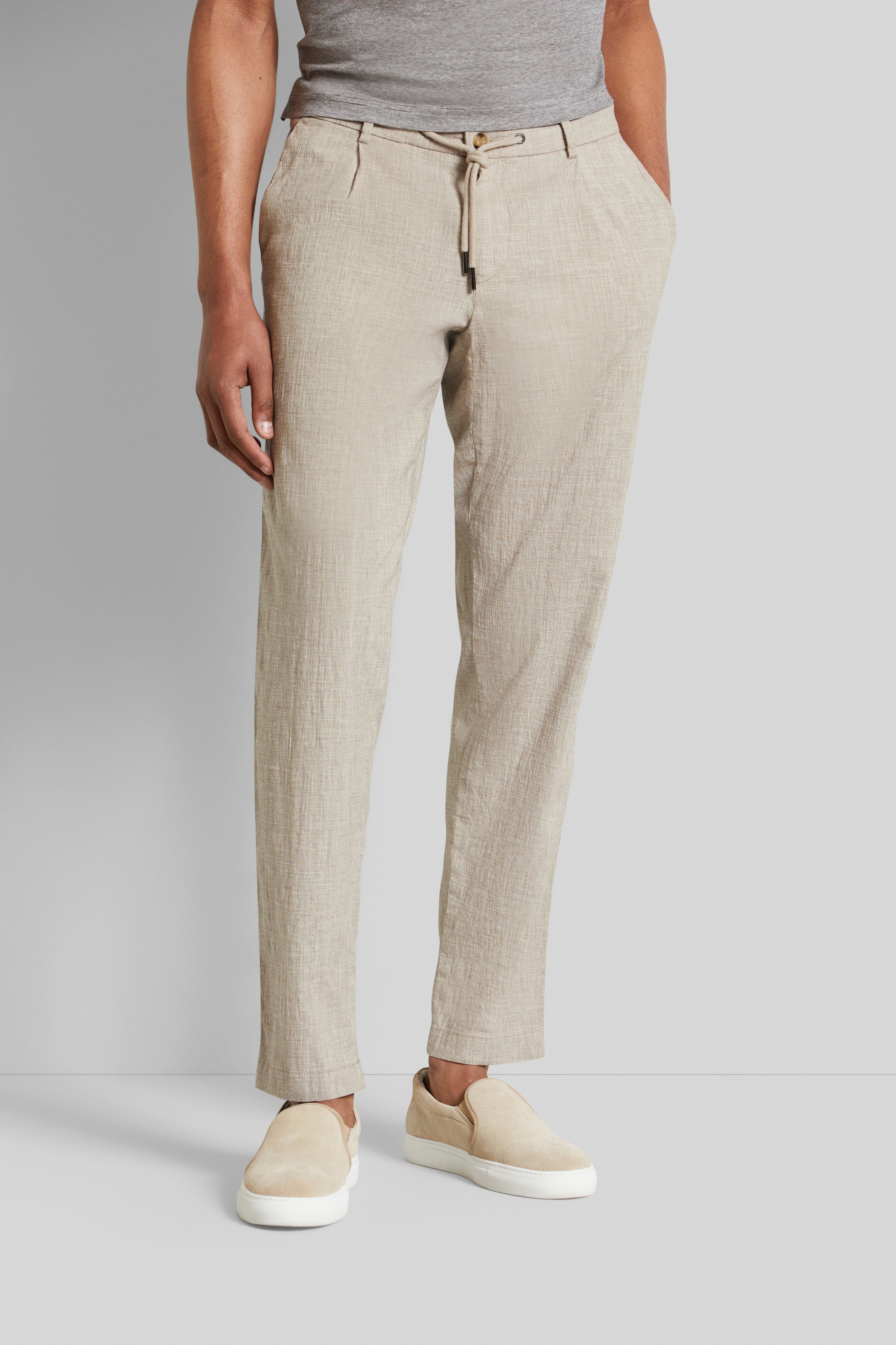 Beige Chinohose von bugatti, leger getragen mit grauem Shirt und beigen Slippern, Modelbild.