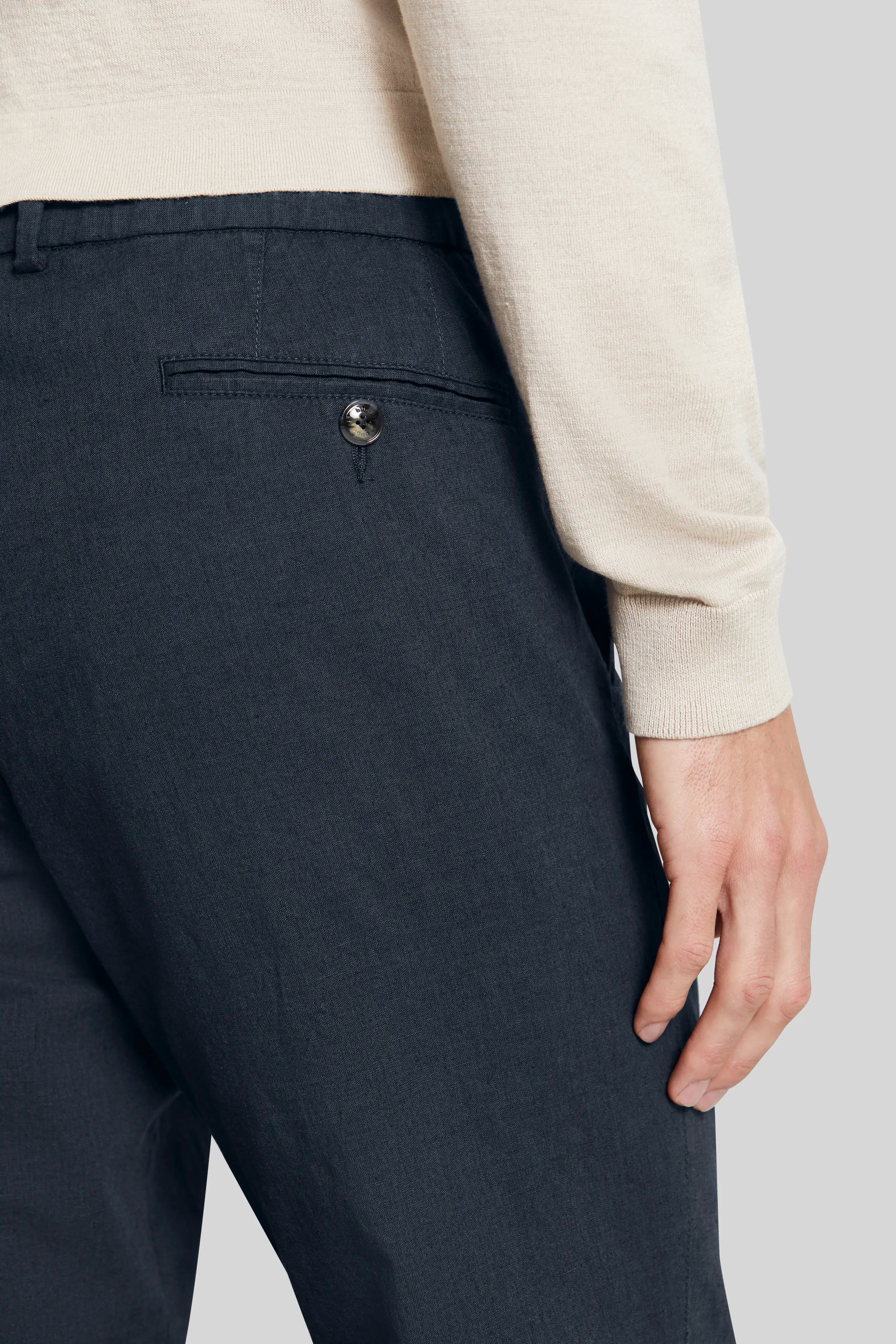 Donkerblauwe bugatti-broek, detailzicht, met beige trui.