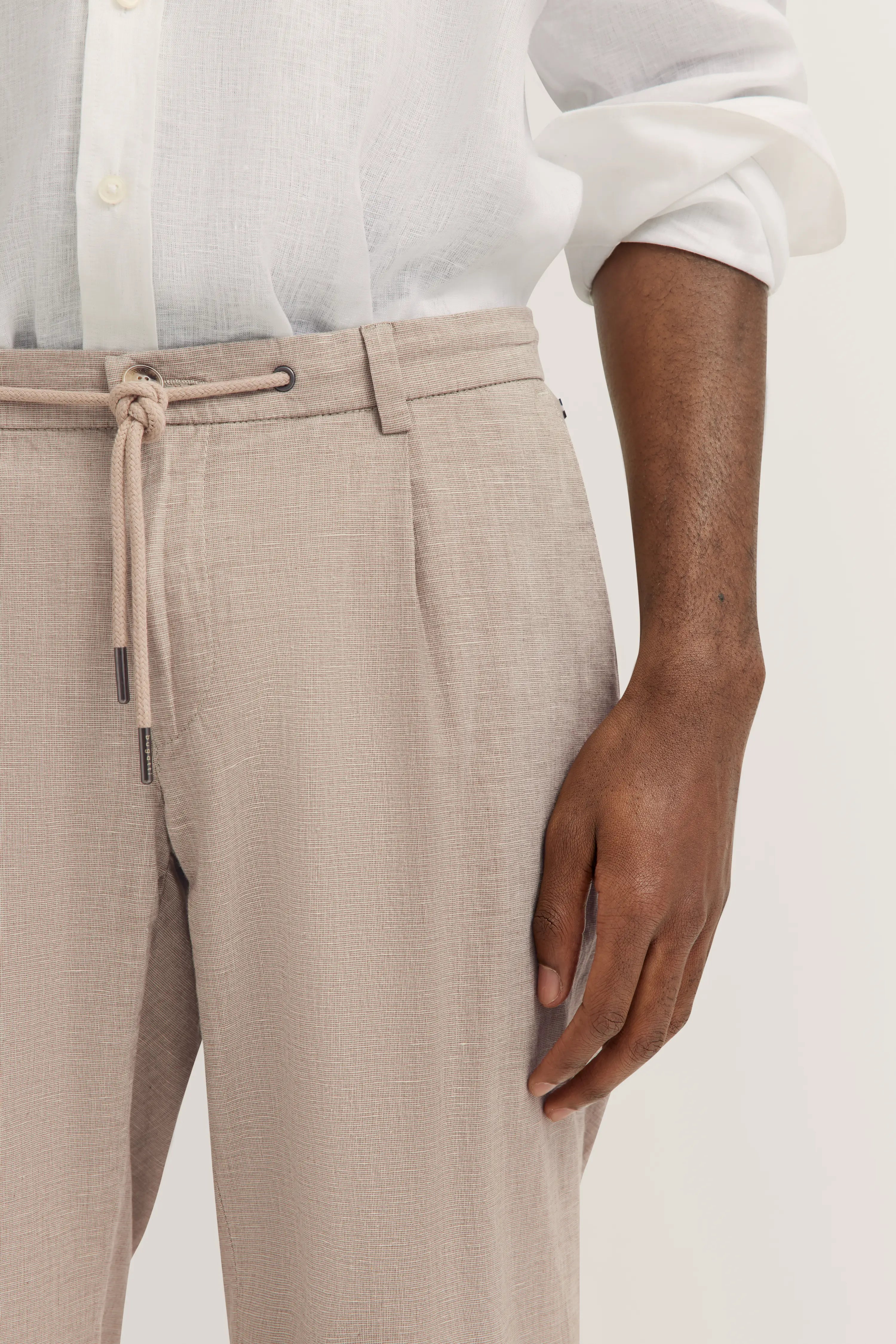 Leinenhose in Beige mit weißem Leinenhemd, legerer Stil, Detailaufnahme, bugatti.