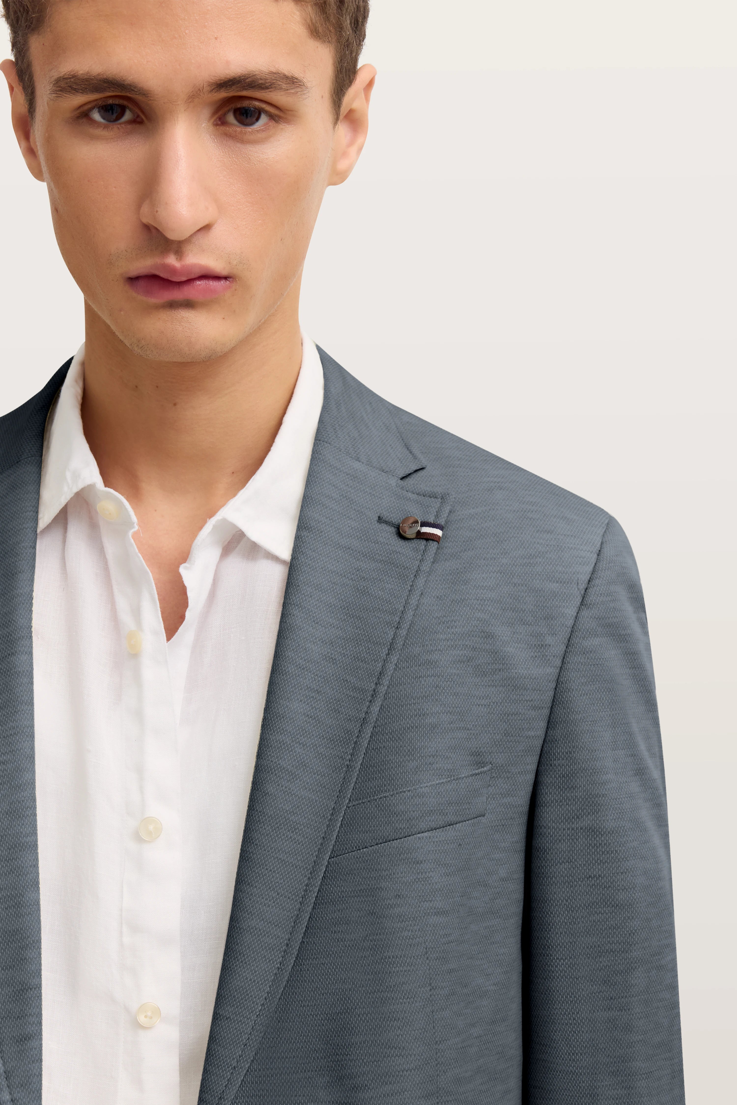 Grauer bugatti-Blazer über weißem Hemd, Modelbild, halbnah, Blick nach vorne.