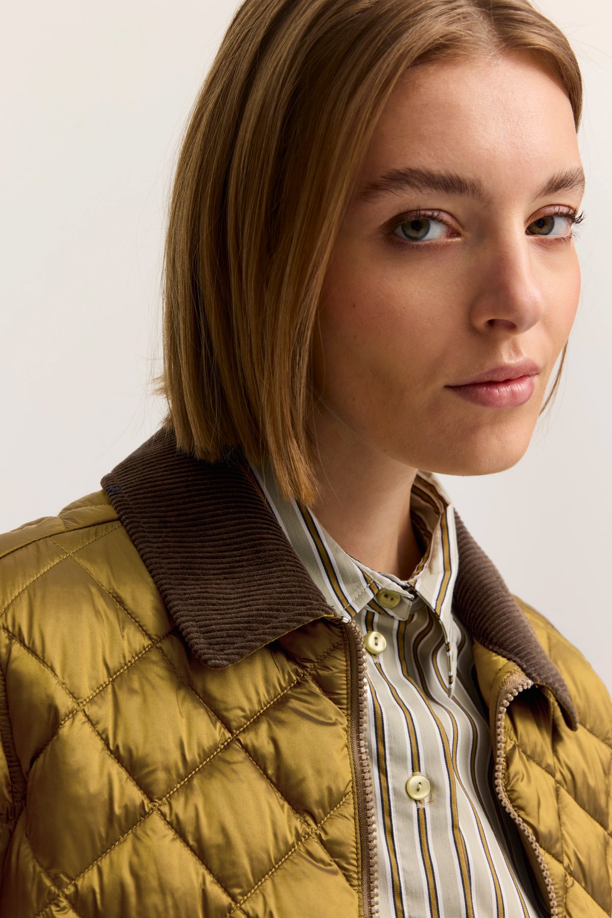 Büstenbild mit bugatti Steppjacke in Olivgrün und gestreiftem Hemd, stilvoll und elegant.