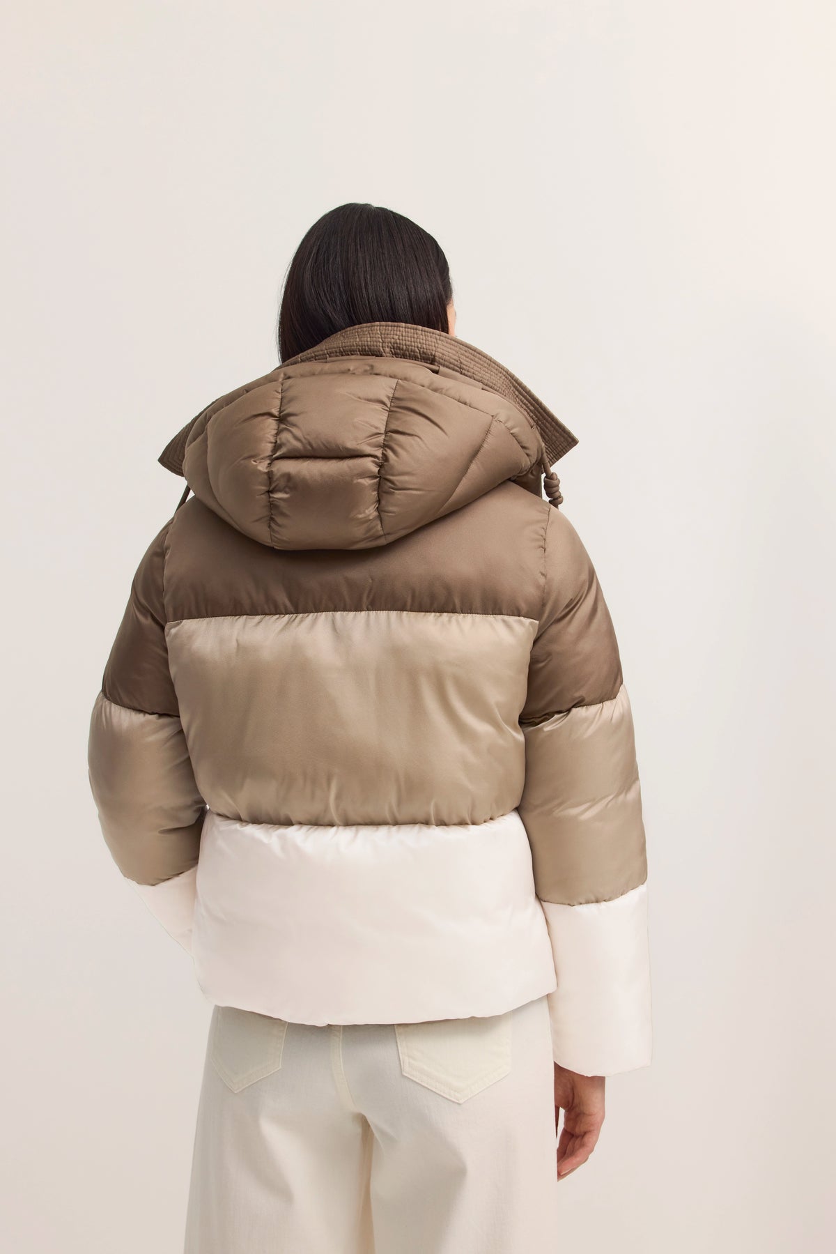 bugatti Modelbild, Beige-Braune Daunenjacke, Rückansicht, entspannte Pose.