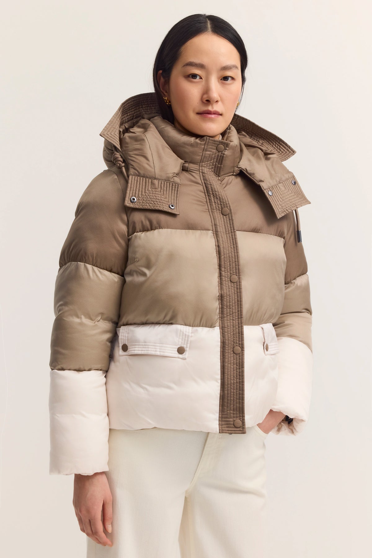 Damen-Pufferjacke in Beige und Weiß, Modelbild, entspanntes Posing, bugatti Stil.