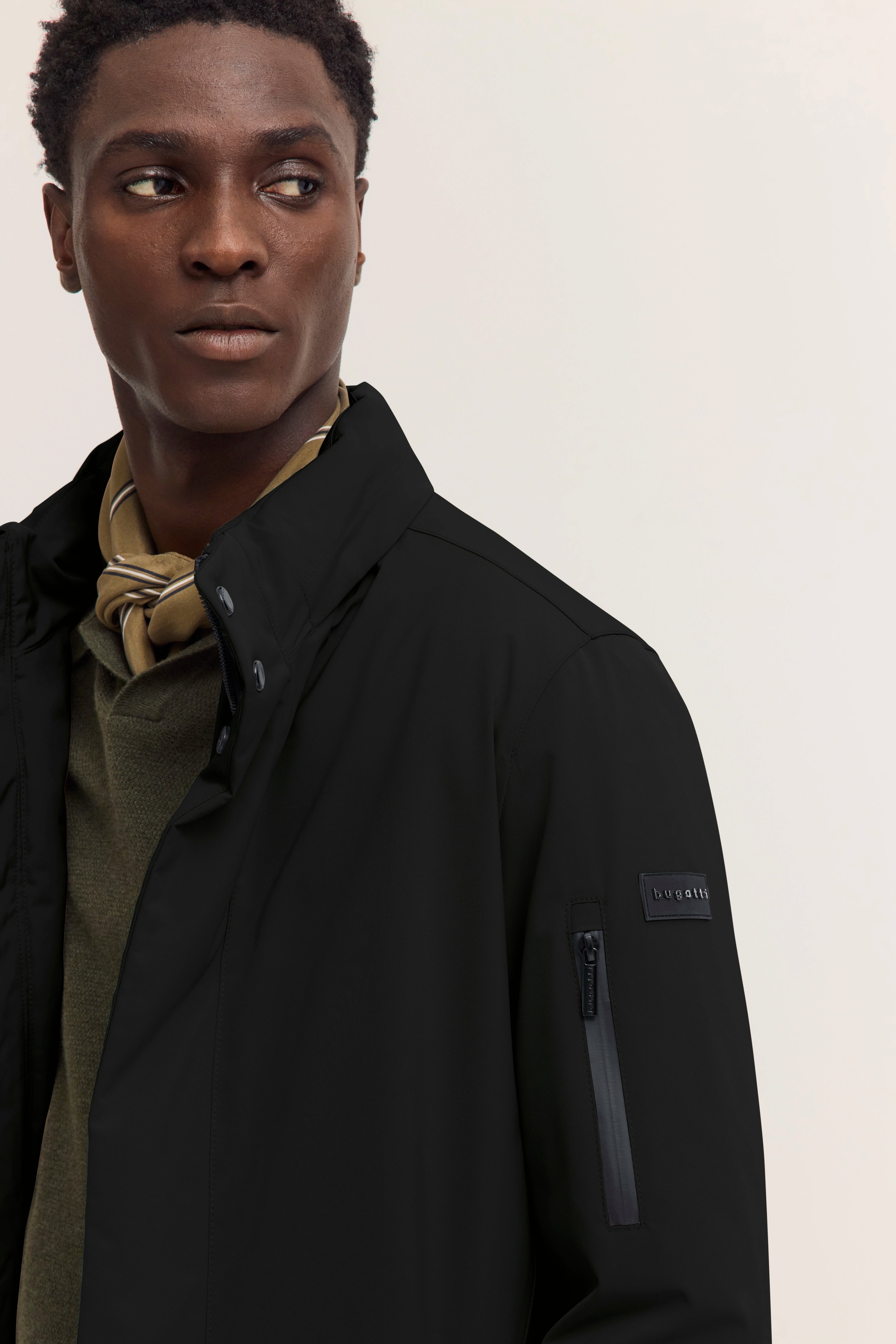 Schwarze bugatti-Jacke, Rückansicht, legeres Model, helle Hose.