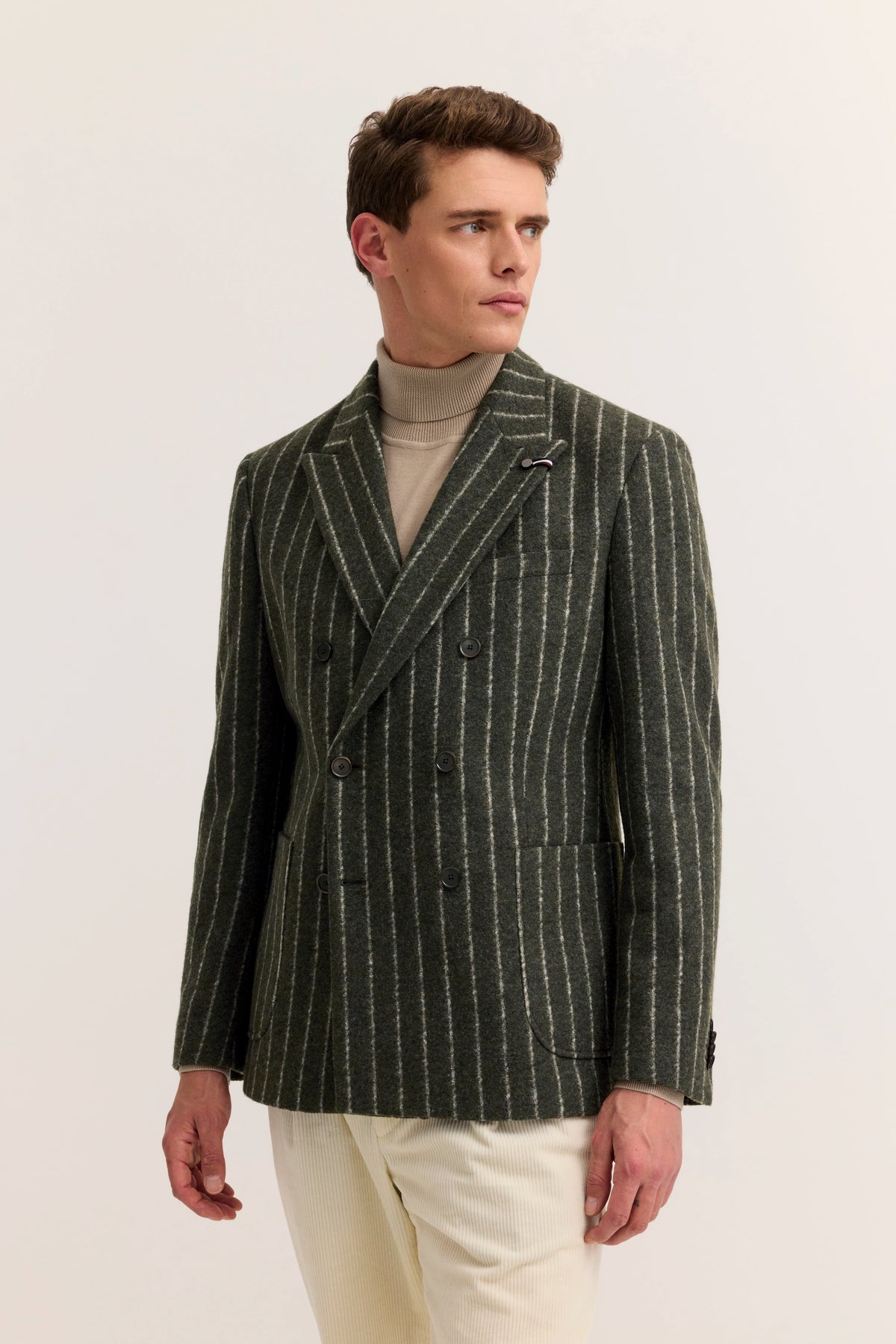 Modelbild: Mann in gestreiftem, graugrünem bugatti Sakko mit Rollkragenpullover, seitlich blickend.