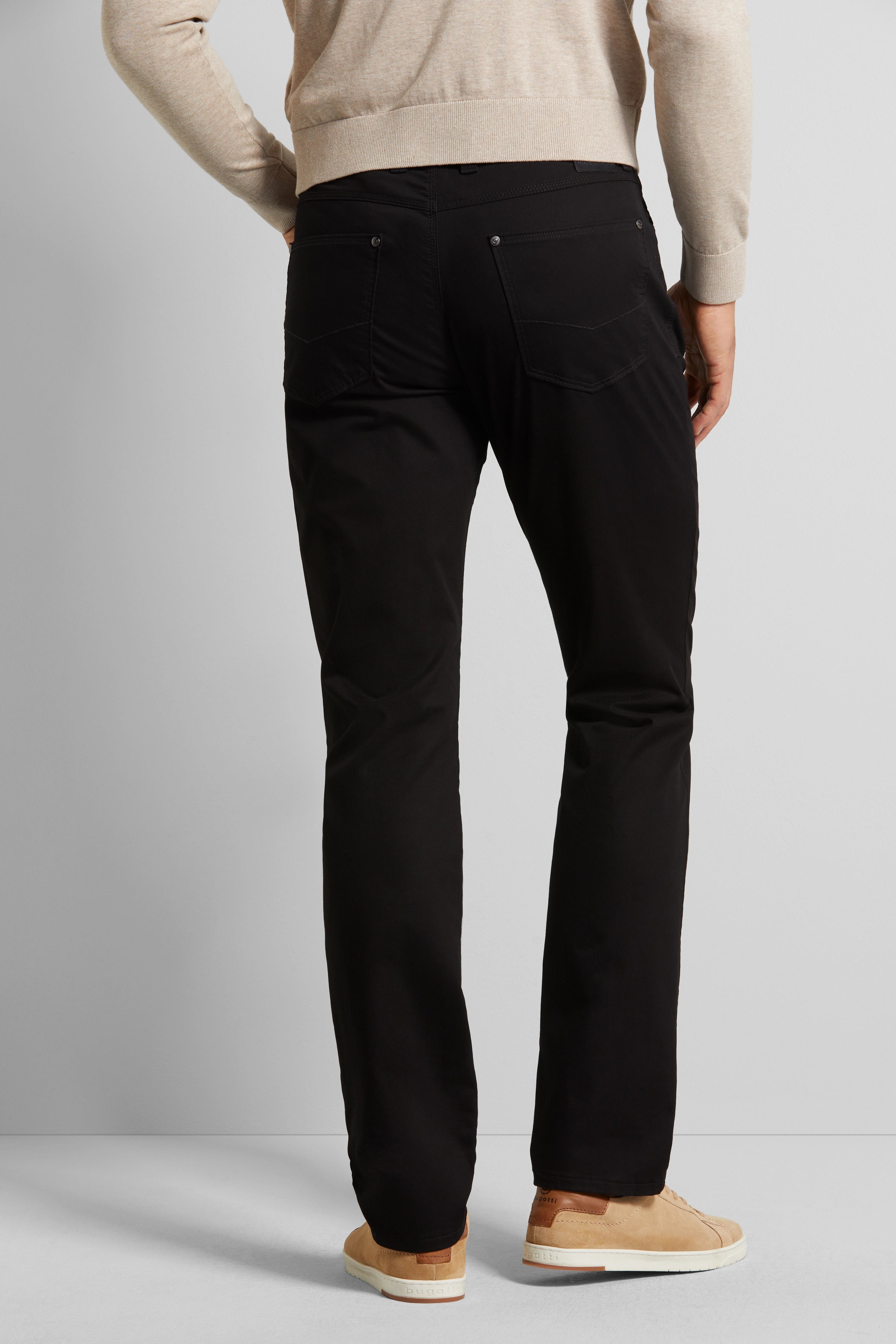 Beigefarbener Pullover, schwarze Hose, Model von hinten, beige Sneaker, bugatti.