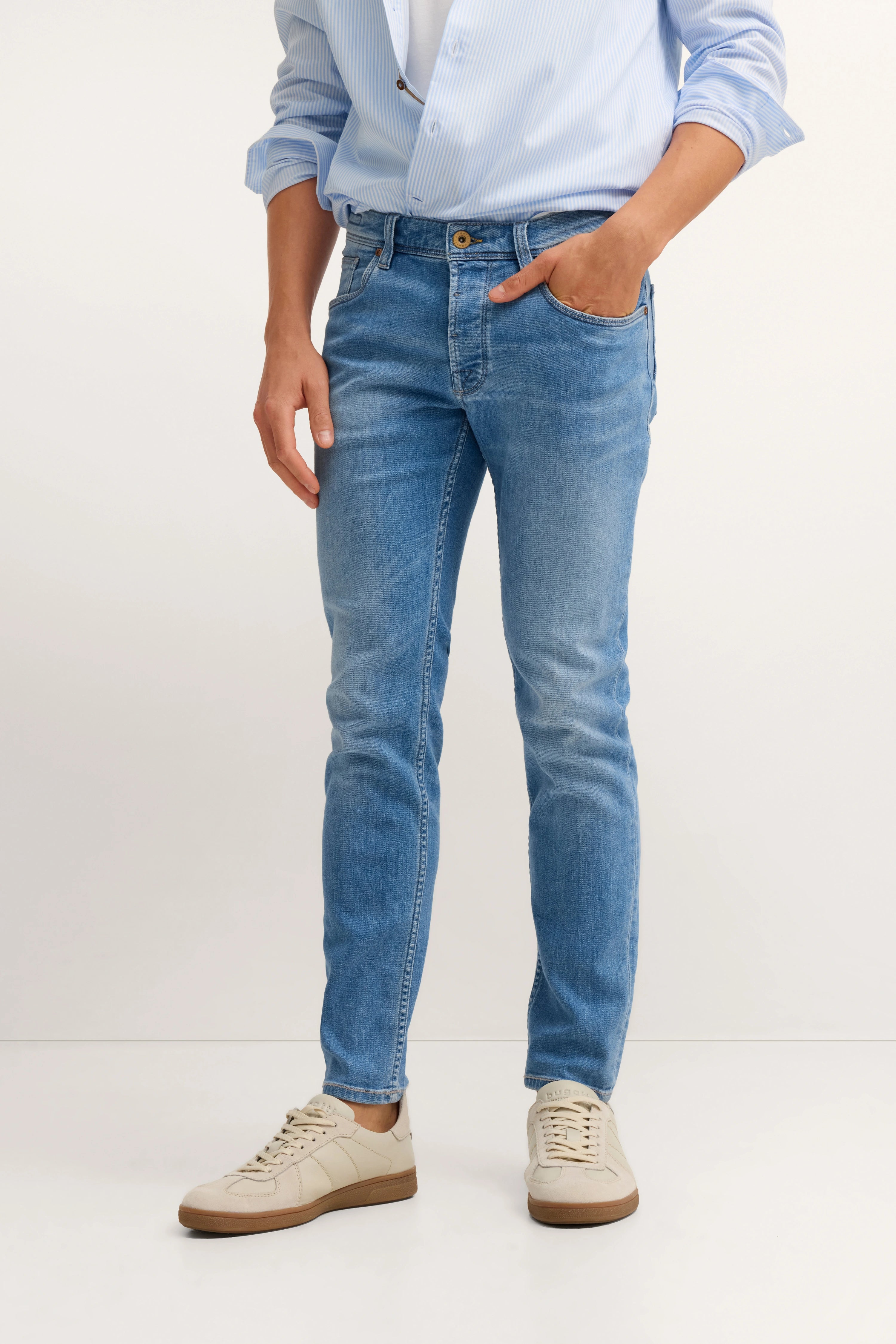 Blaues Hemd, helle Jeans, weiße Sneakers, legeres Modelbild, Hand in Hosentasche.