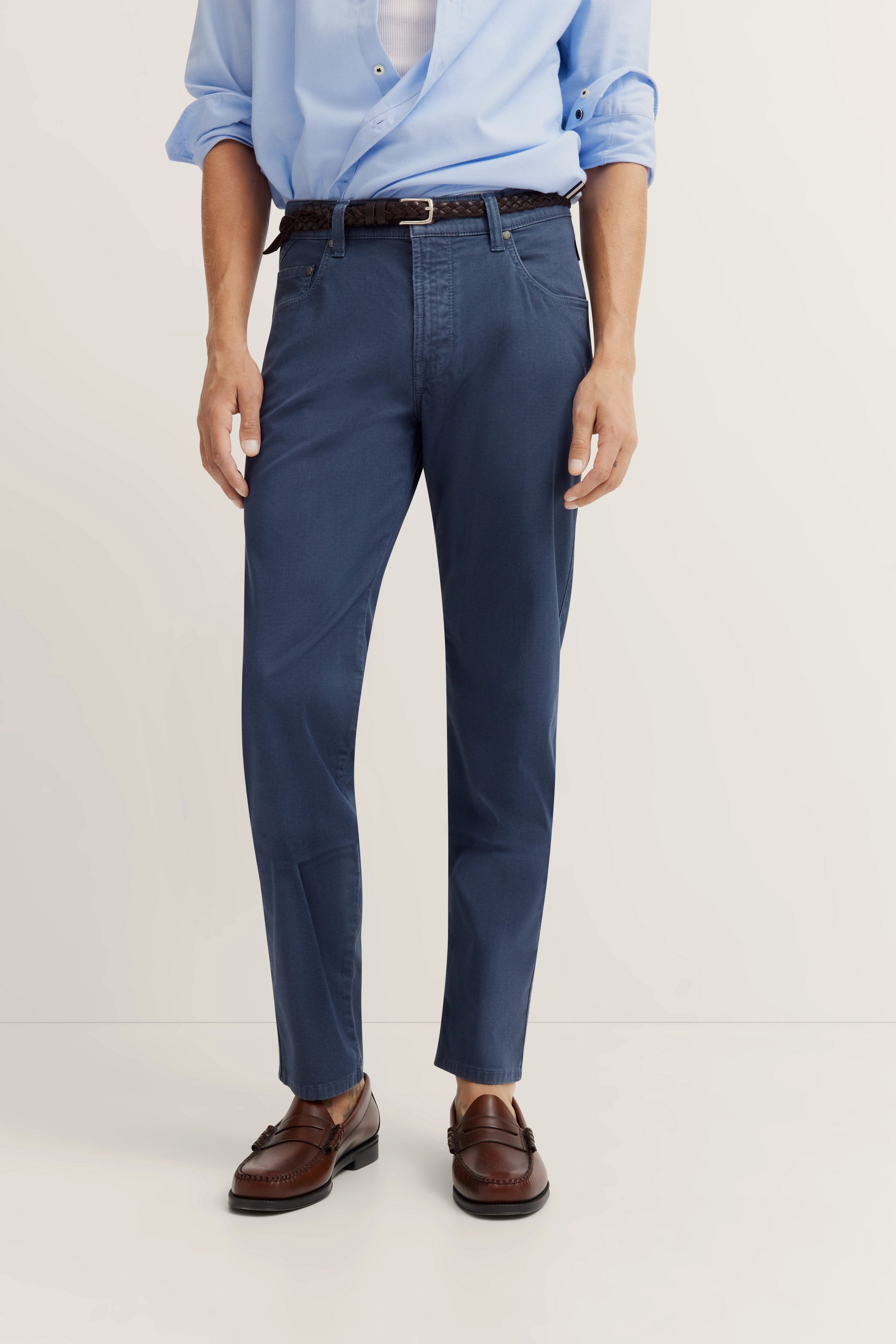 Büstenansicht: Hellblaues Hemd, blaue Hose, braune Loafer.