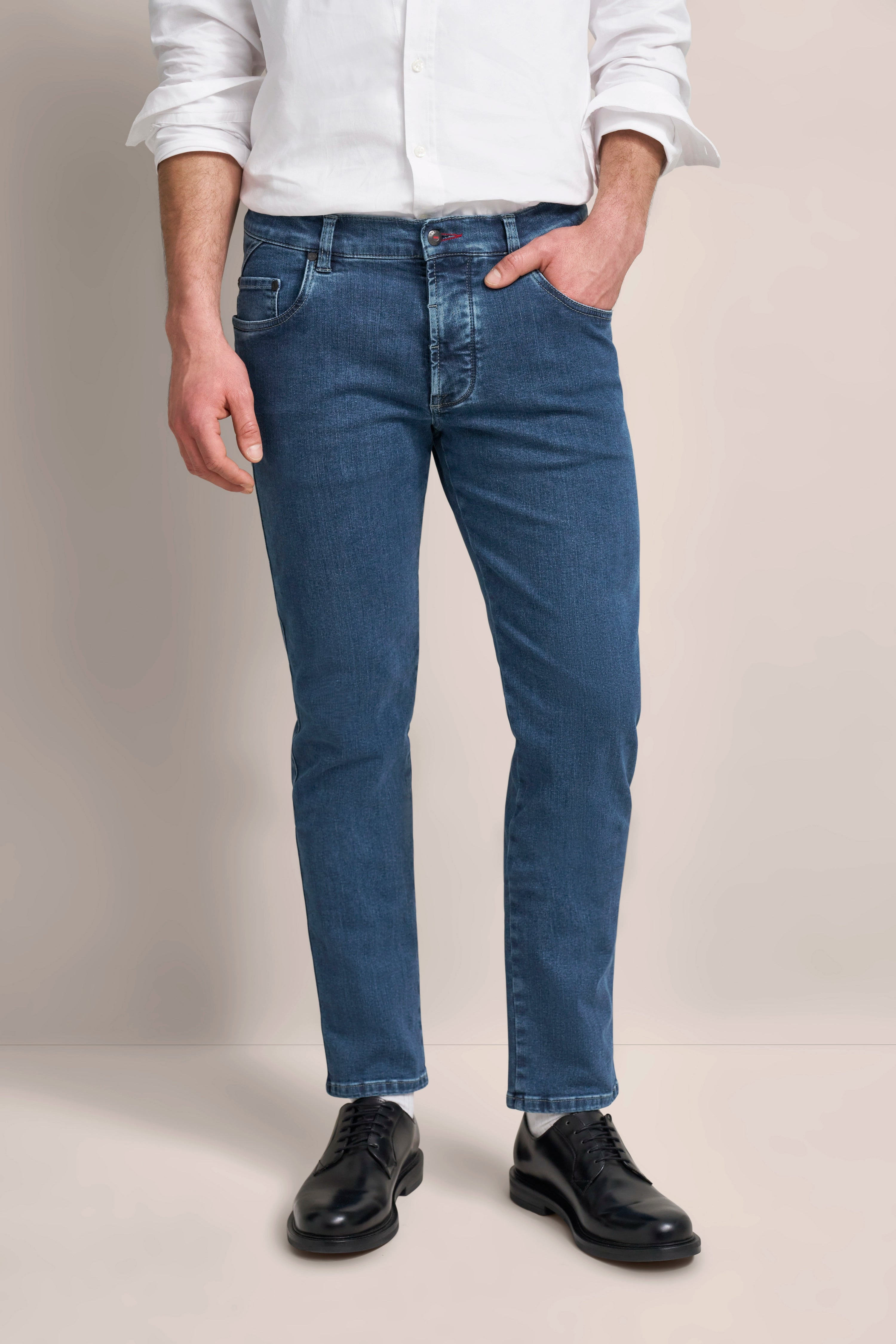 Weiße Hemd und blaue Jeans von bugatti, legeres Modelbild, lässige Hand in Hosentasche.