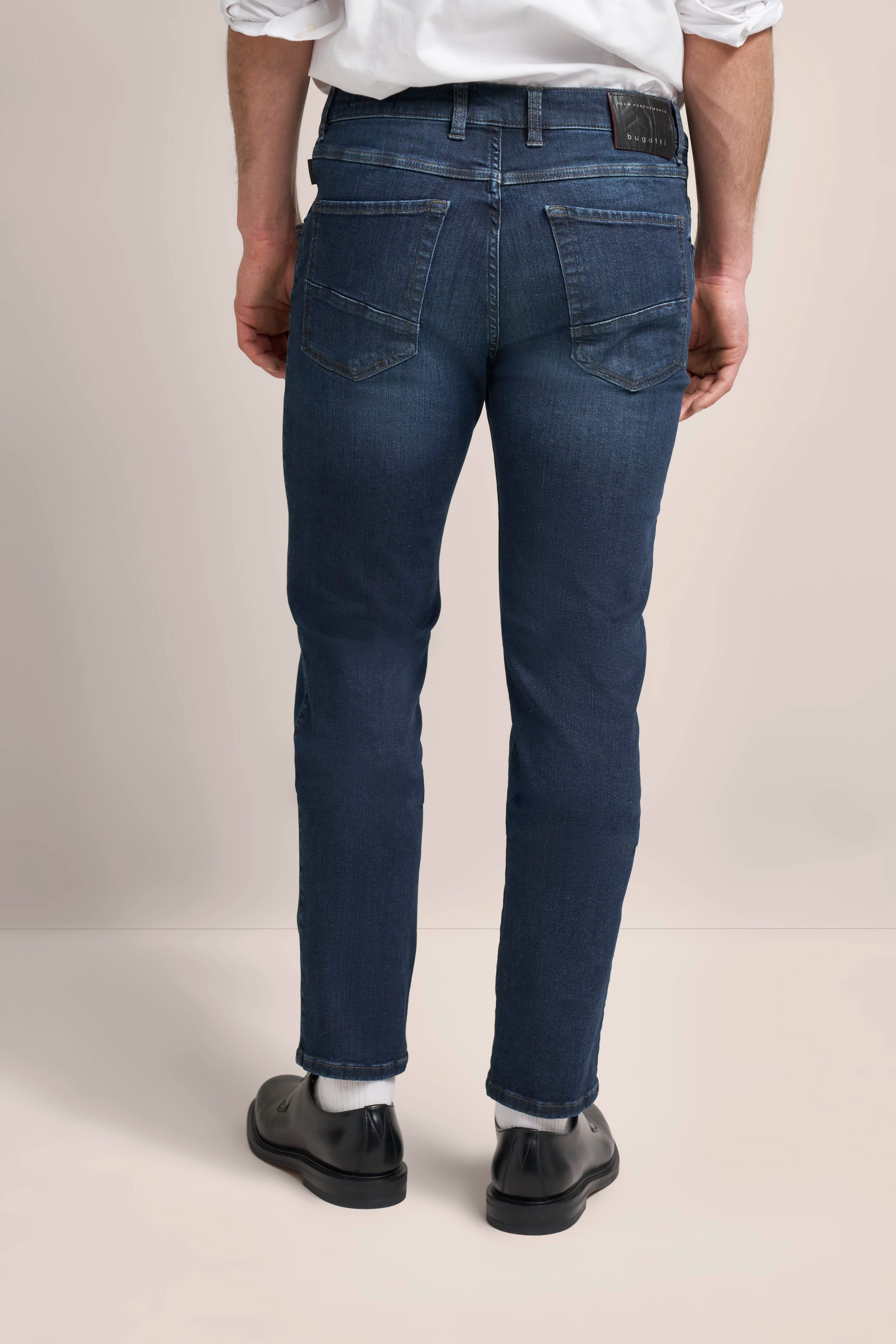 Jeans in Dunkelblau, Büstenbild, kombiniert mit schwarzem Schuh. Stilvoll und zeitlos von bugatti.
