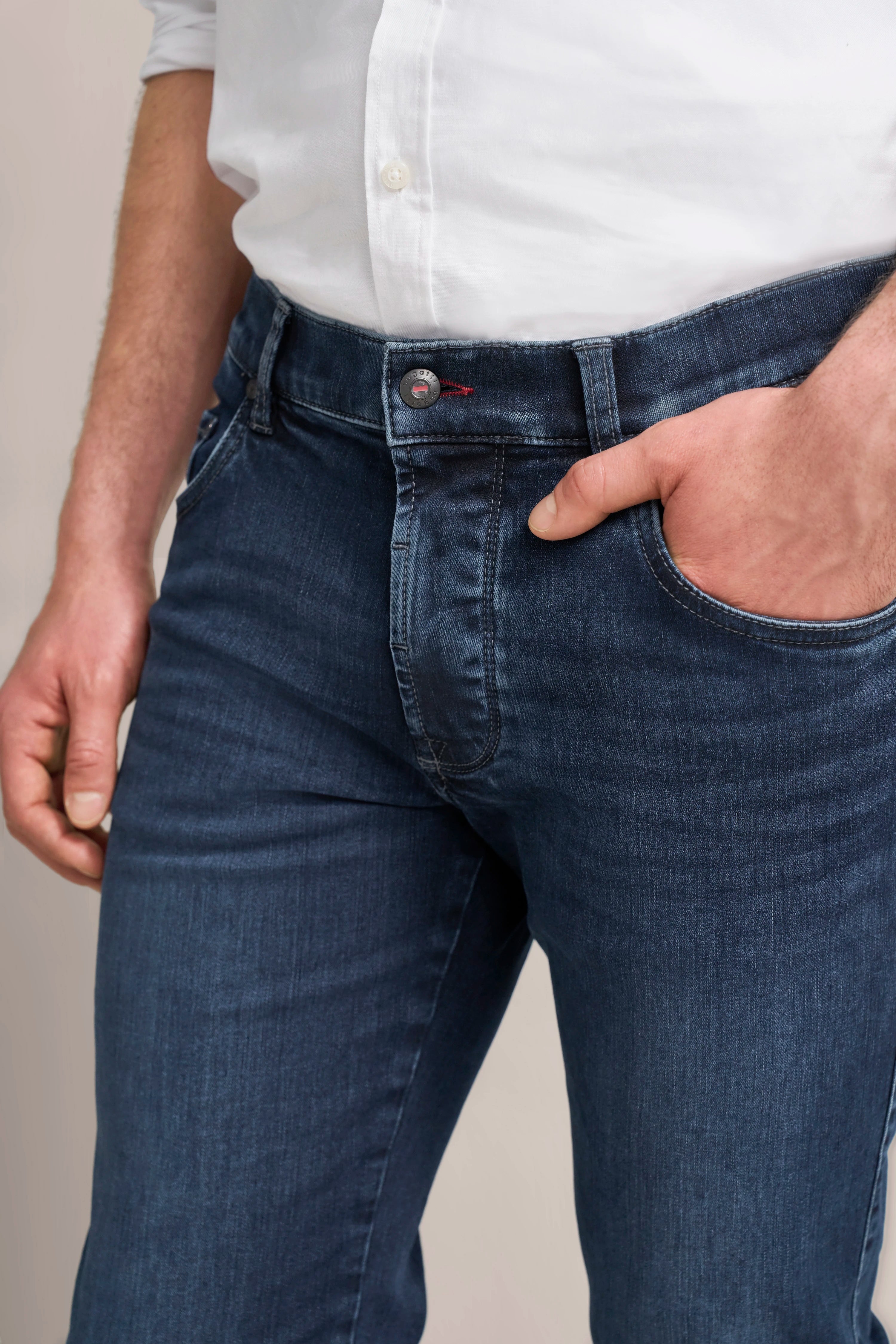 Dunkelblaue Jeans und weißes Hemd von bugatti, leger getragen, Detailansicht.