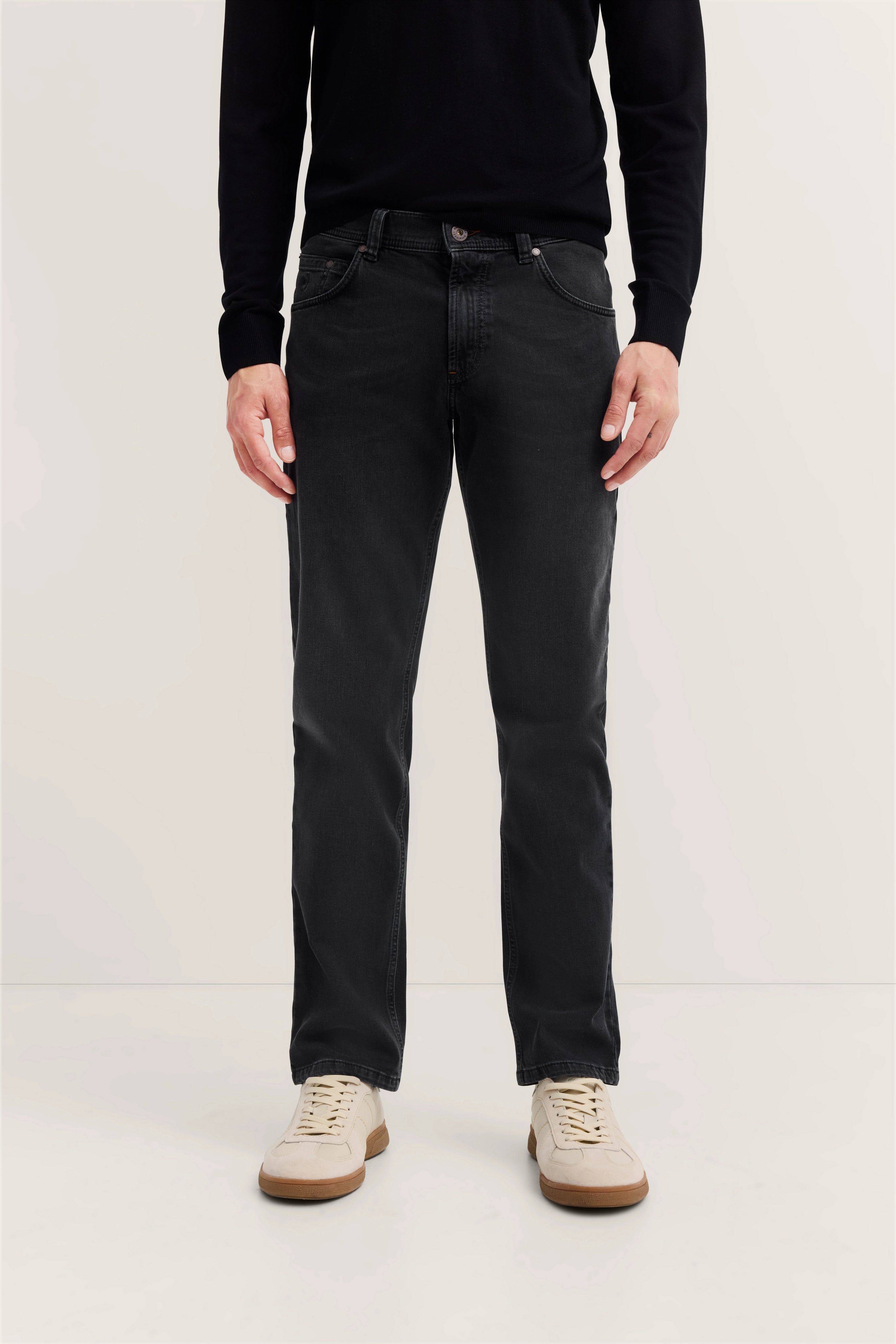 Schwarzer bugatti Pullover, dunkle Jeans, Modelbild, entspannter Stand, helle Sneaker.