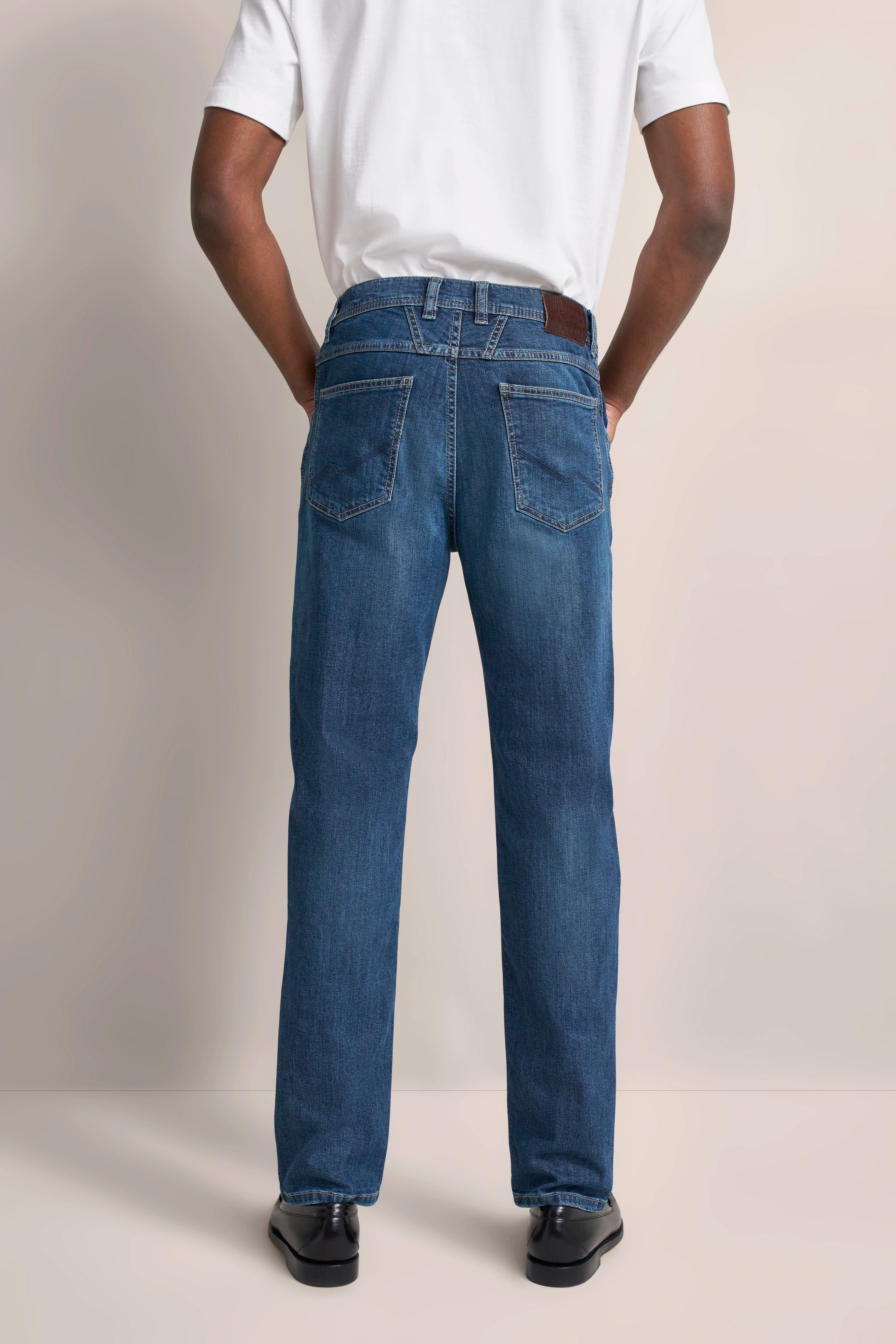 Men's blue jeans, casual model back view, white t-shirt, black shoes, \"bugatti\" style.