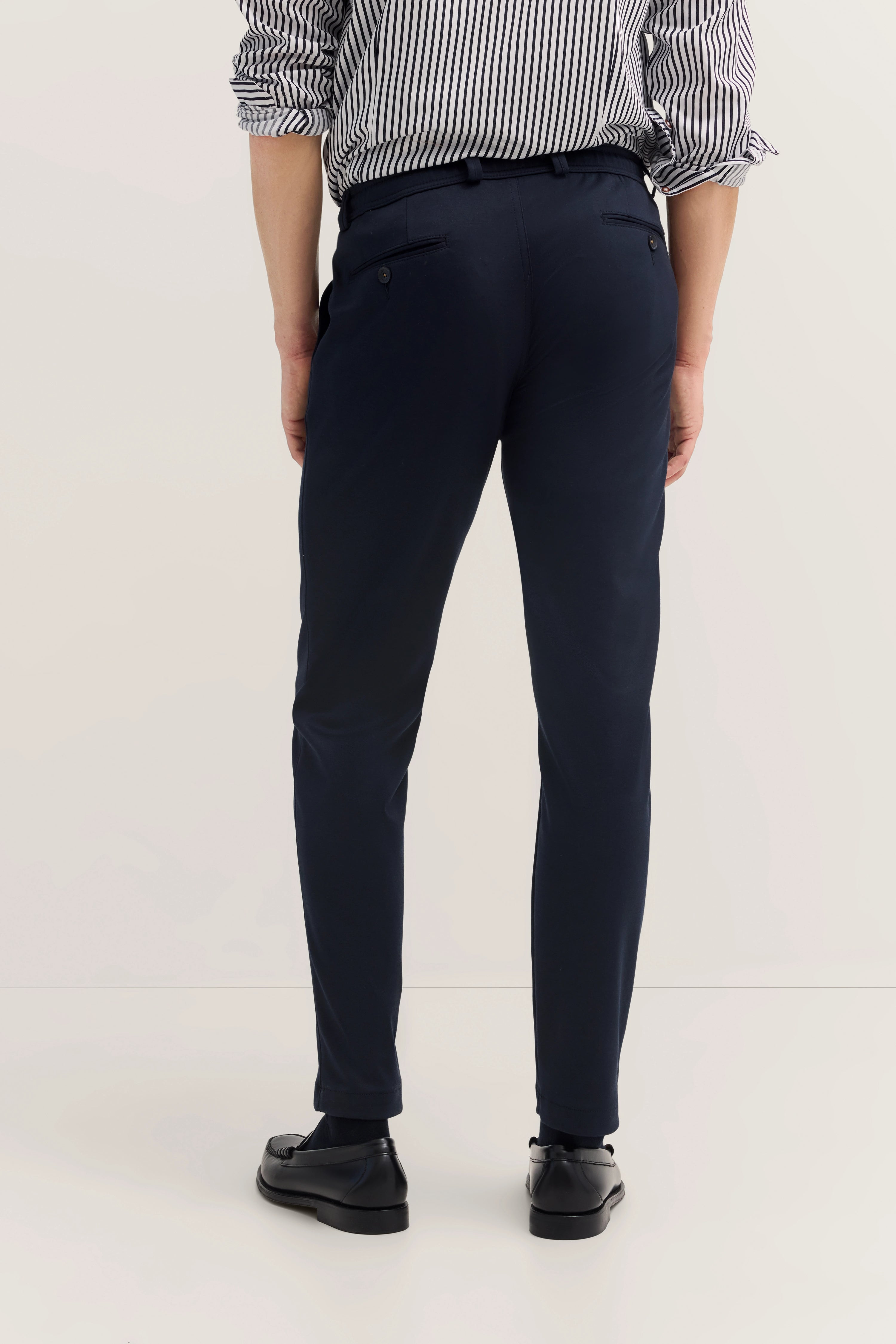 Bugatti Outfit: gestreiftes Hemd, dunkelblaue Hose. Modelbild, Rückenansicht.