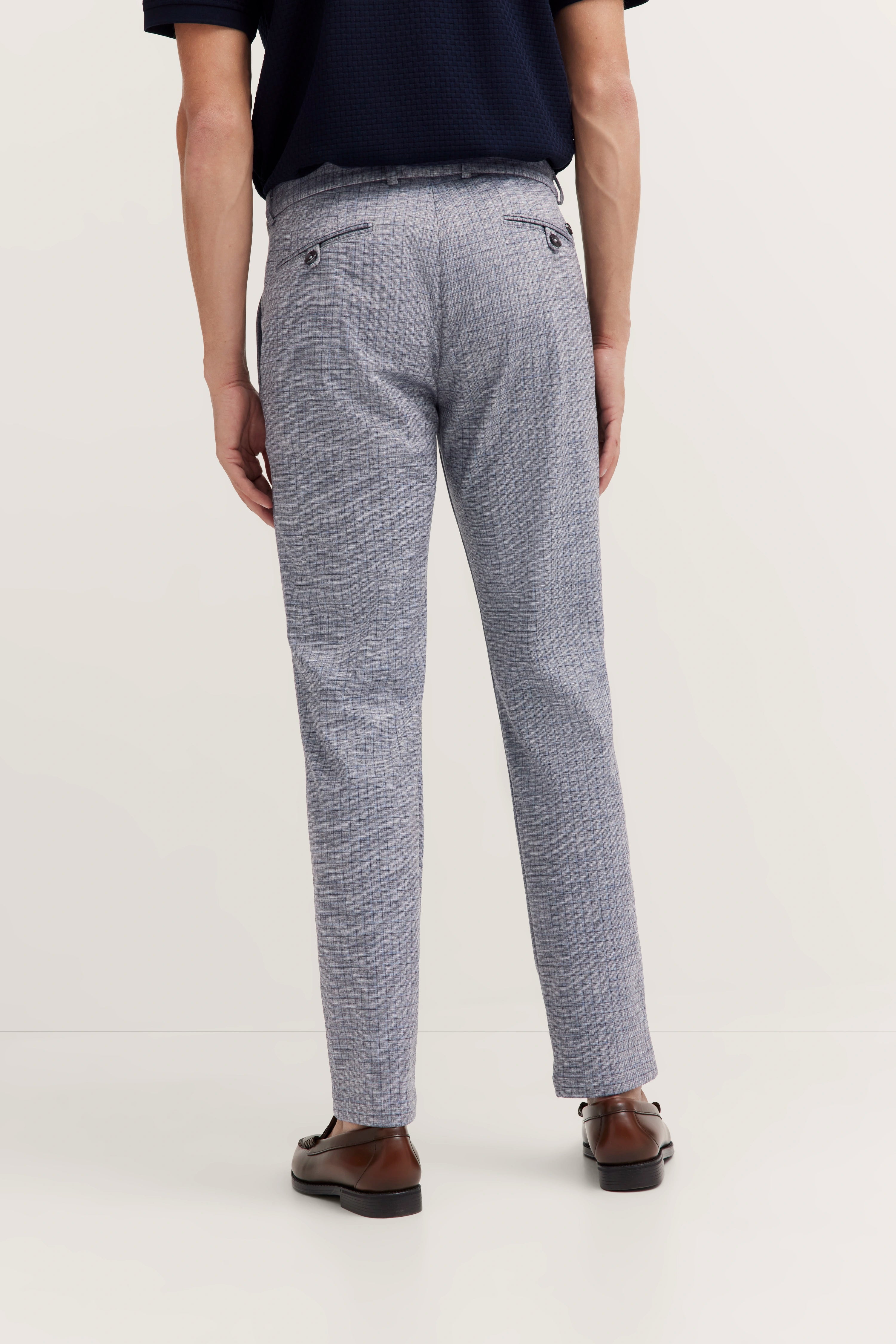 Graue bugatti Hose mit feinem Muster, legeres Modelbild von hinten, kombiniert mit dunkelblauem Oberteil.