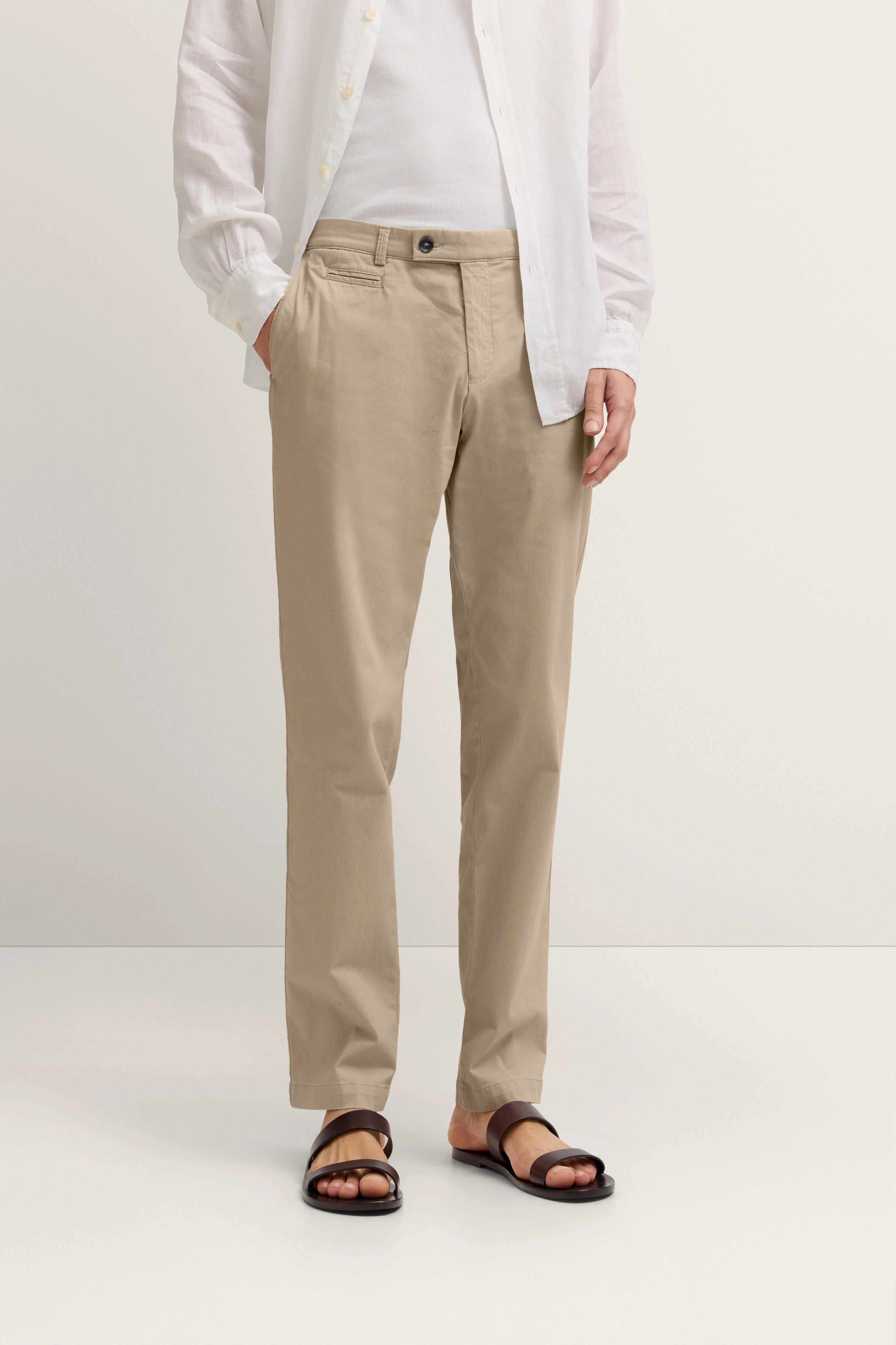 Beiges bugatti Outfit: Hemd, Chino, Sandalen. Model steht leger mit Händen in den Taschen.