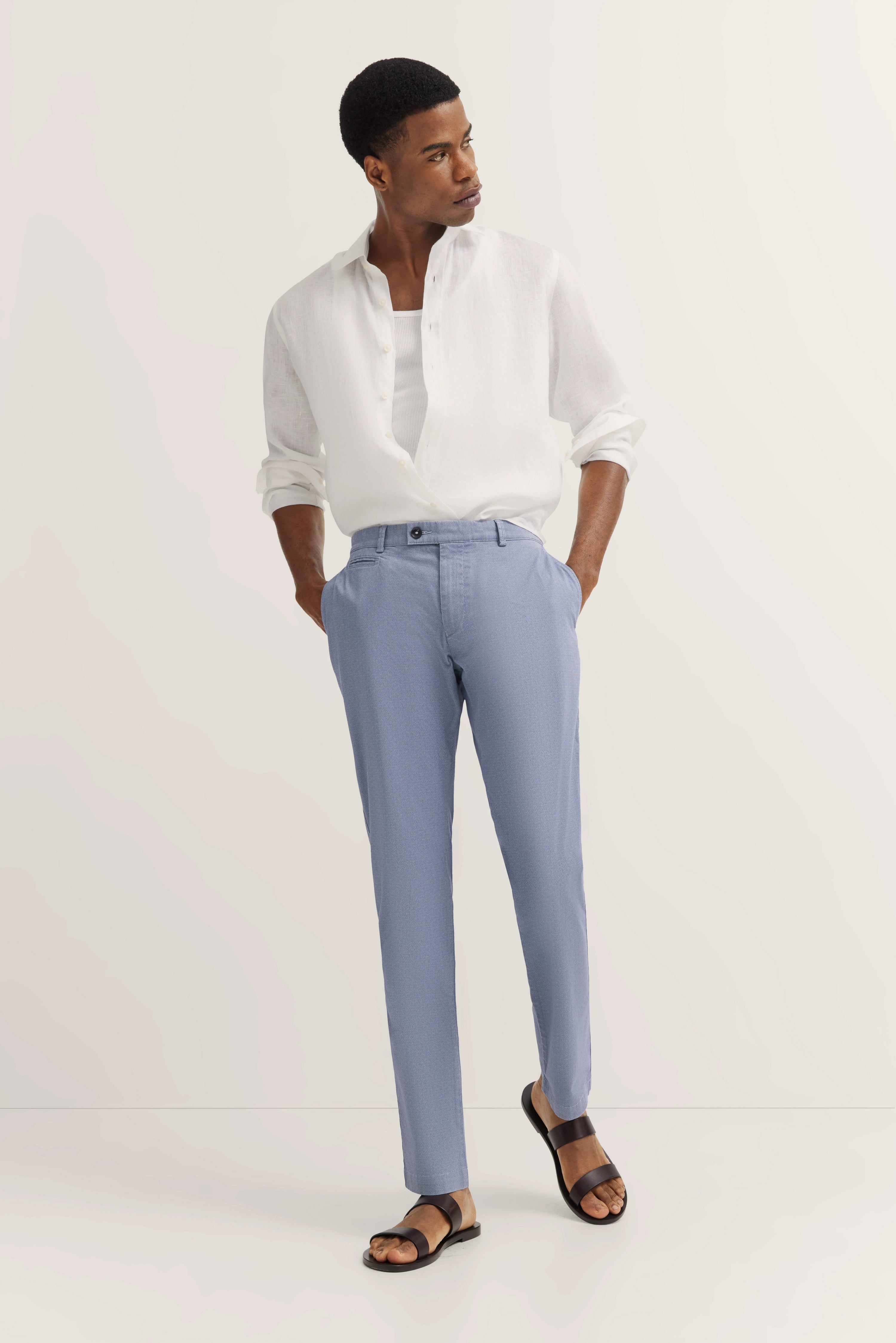 Weißes Hemd und blaue gemusterte Hose von bugatti, legeres Modelbild, lässiger Stand.