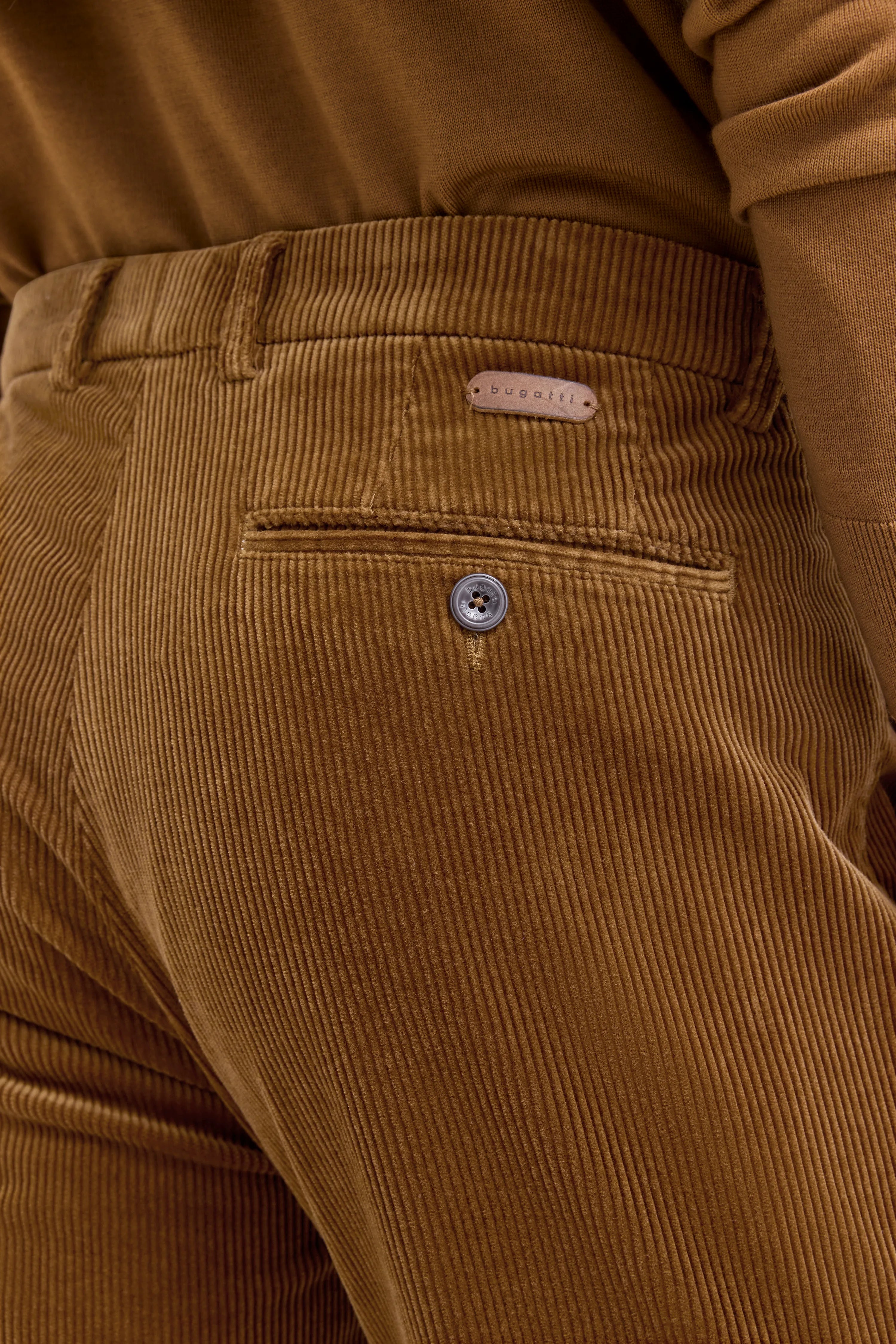Cordhose in warmem Braunton von bugatti, Detailansicht, zeigt stilvolle Verarbeitung und Textur.