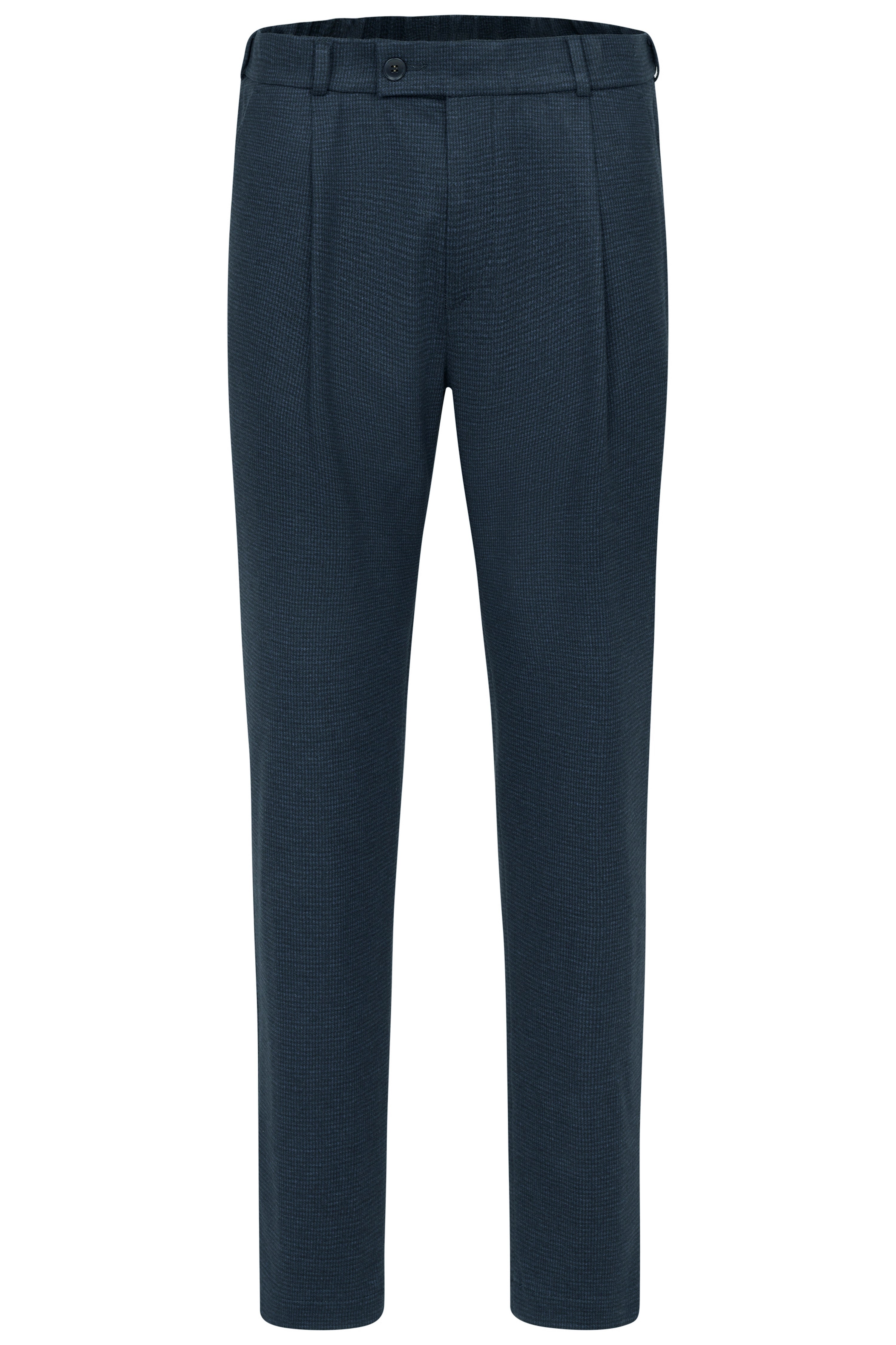 Model steht lässig mit Händen in Taschen.