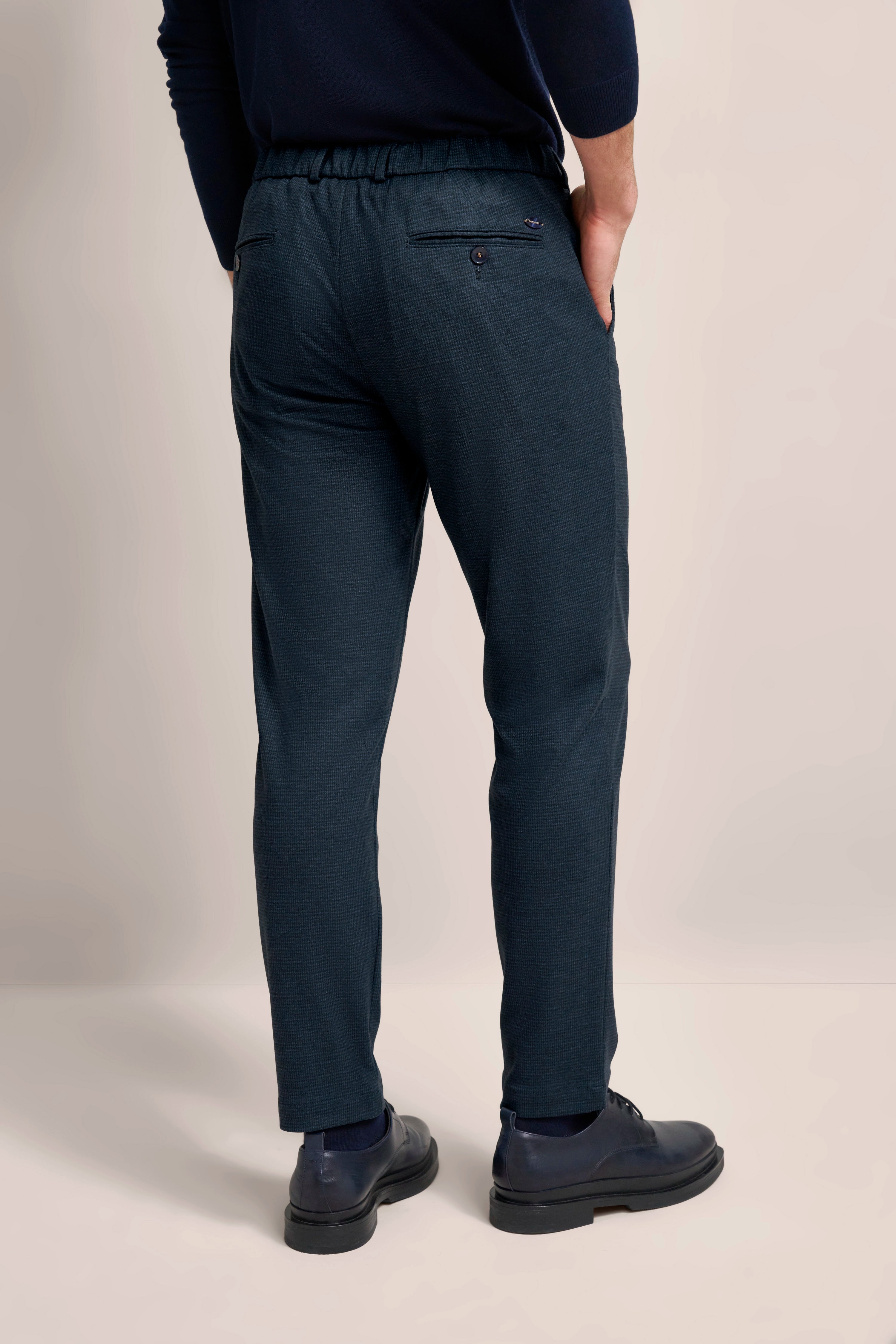 Dunkelblaue bugatti Hose, legeres Modelbild, Rückenansicht, entspannte Pose, stilvoller Look.