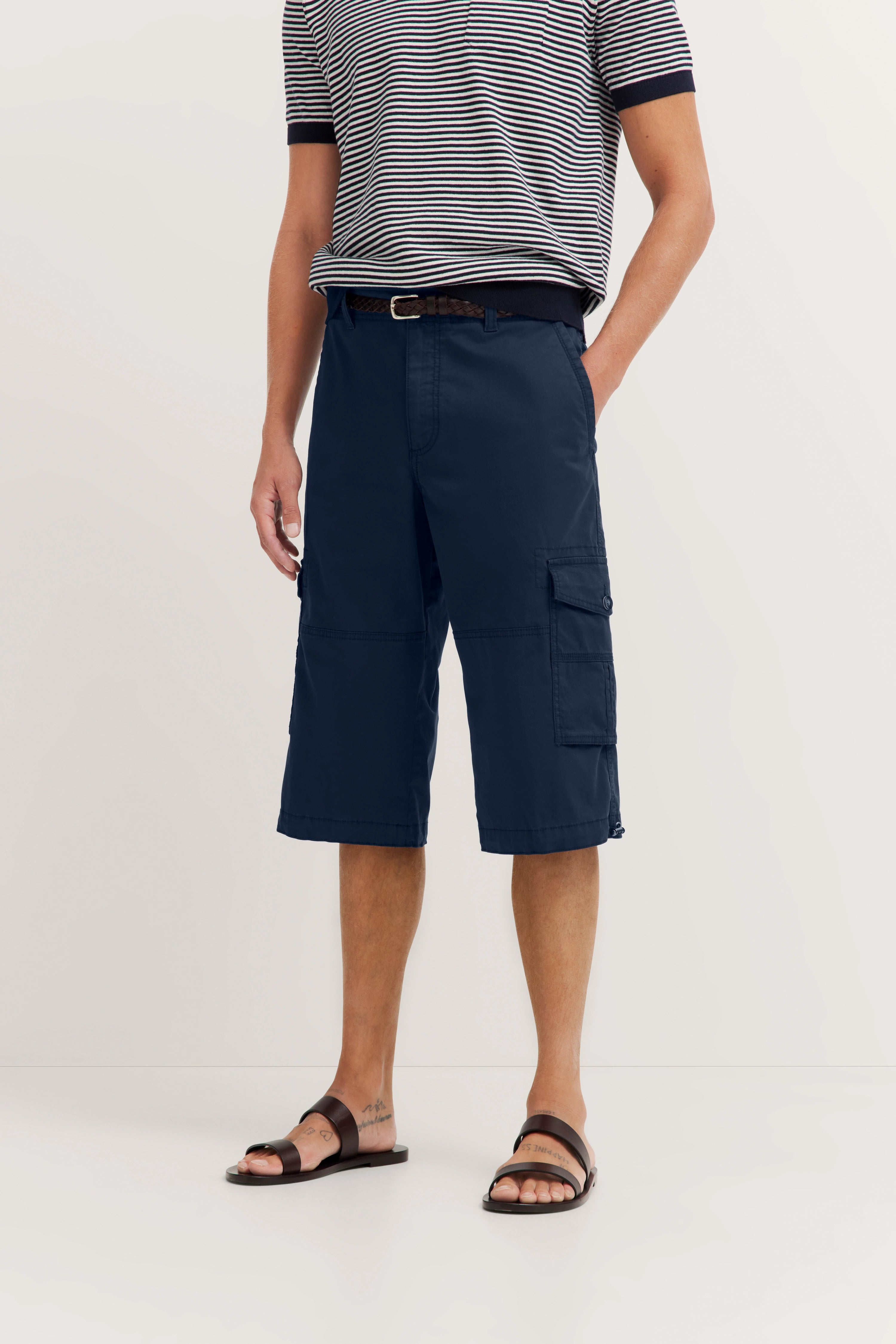 Striped shirt with dark blue cargo bermudas, casual model image, relaxed pose.
