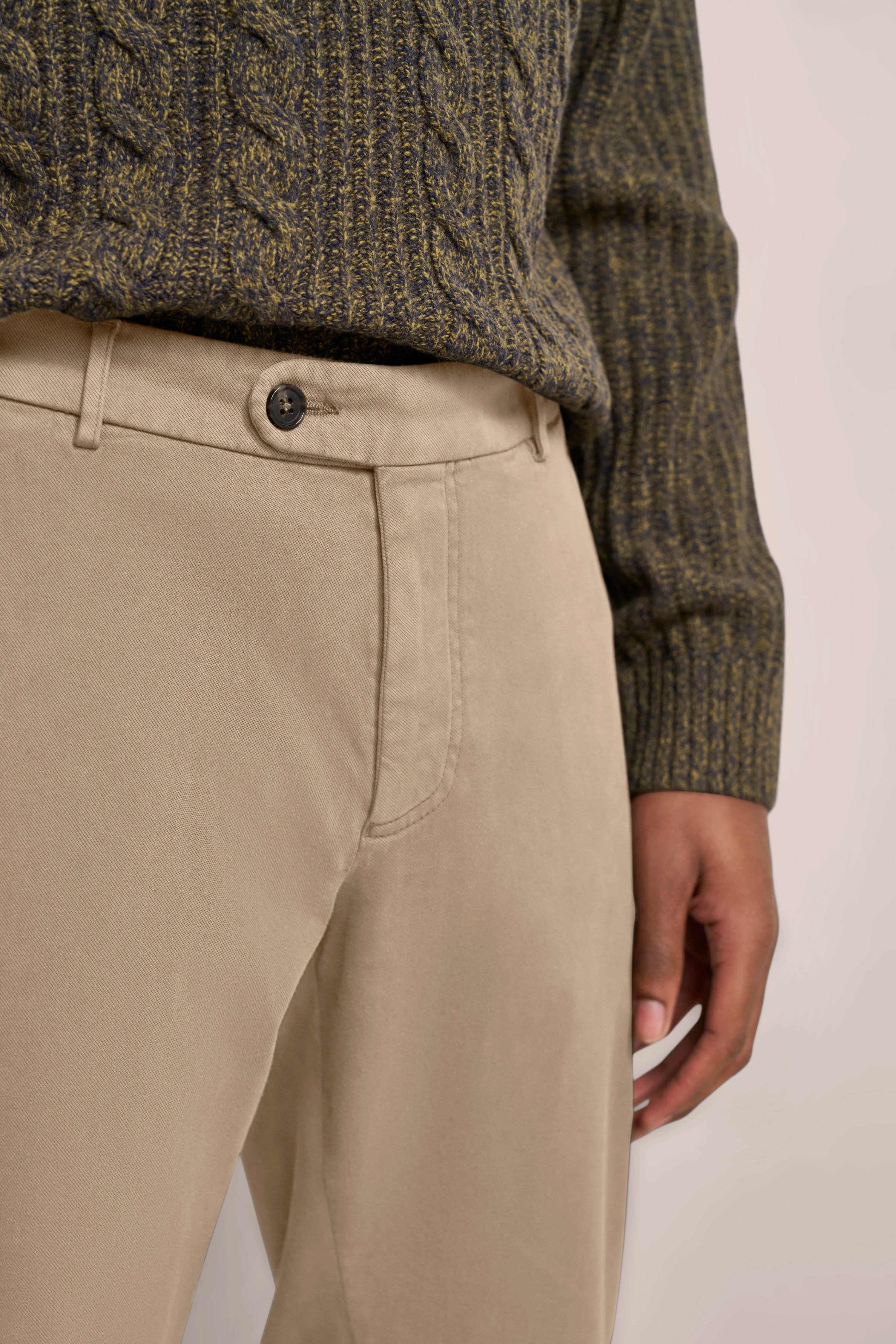 Beigefarbene Chinohose und olivgrüner Strickpullover, legeres Büstenbild, bugatti Stil.