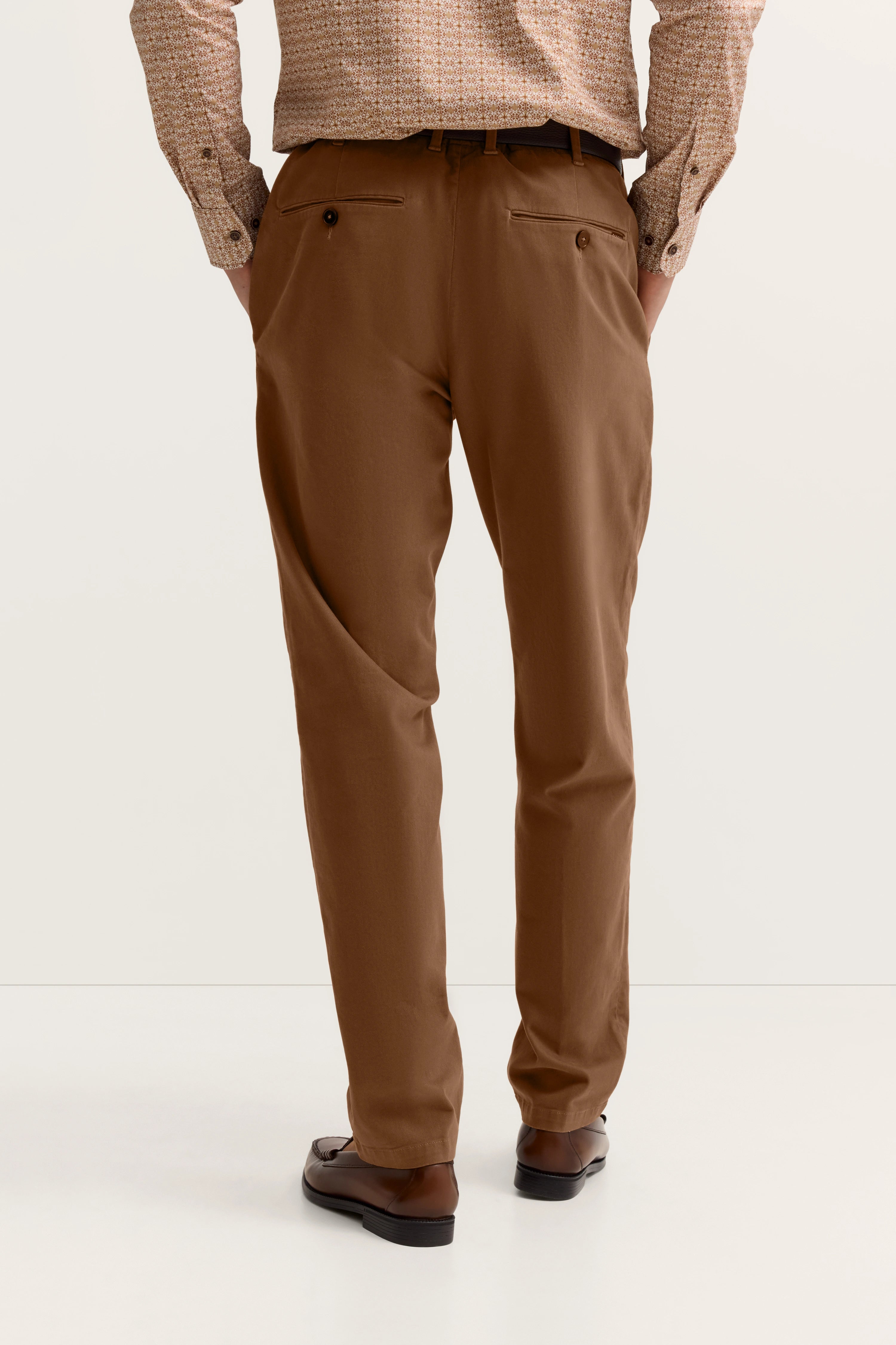 Braune Chinohose, beige gemustertes Hemd, legeres Büstenbild, bugatti Stil.