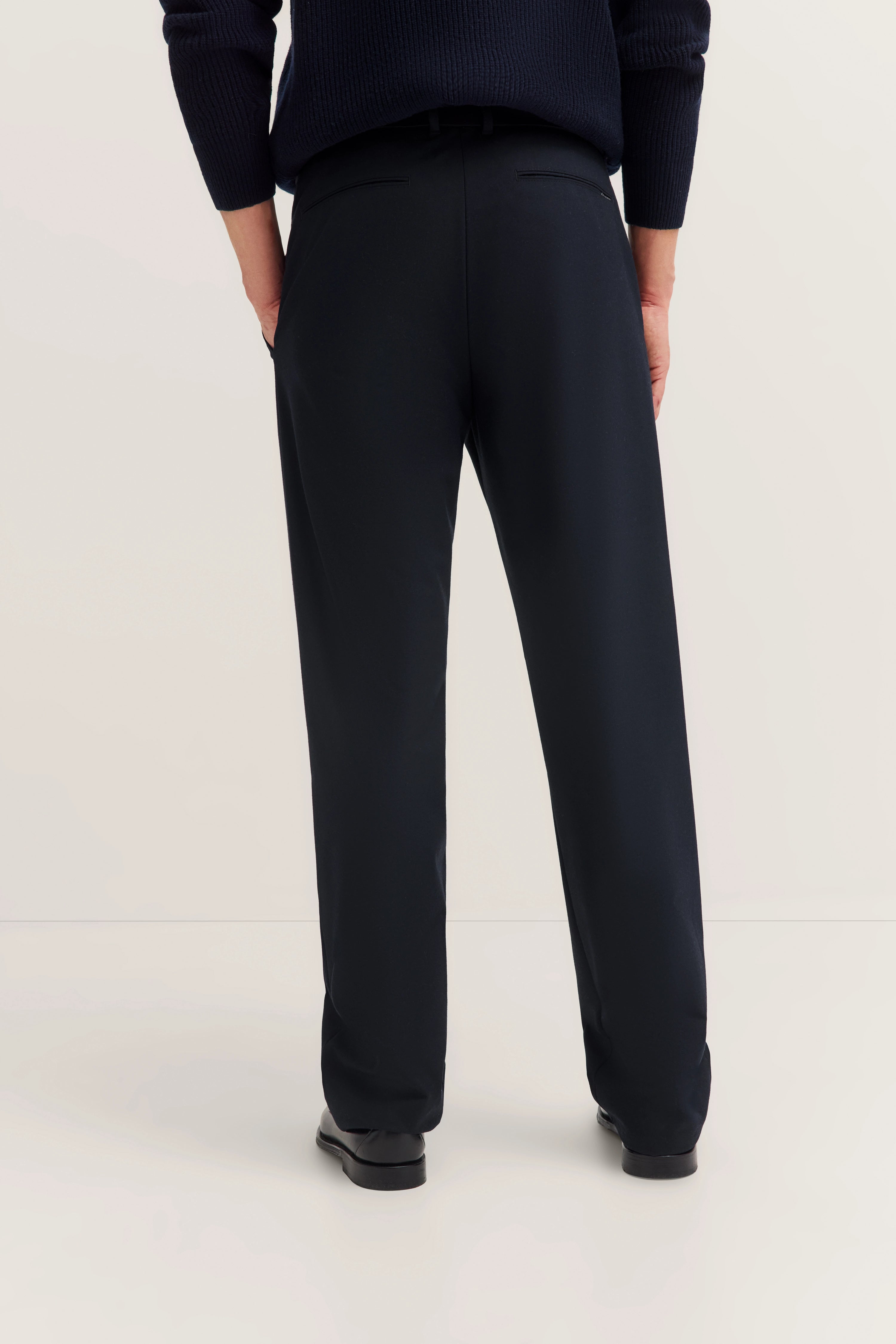 Man in black bugatti trousers, rear view, casual model shot.