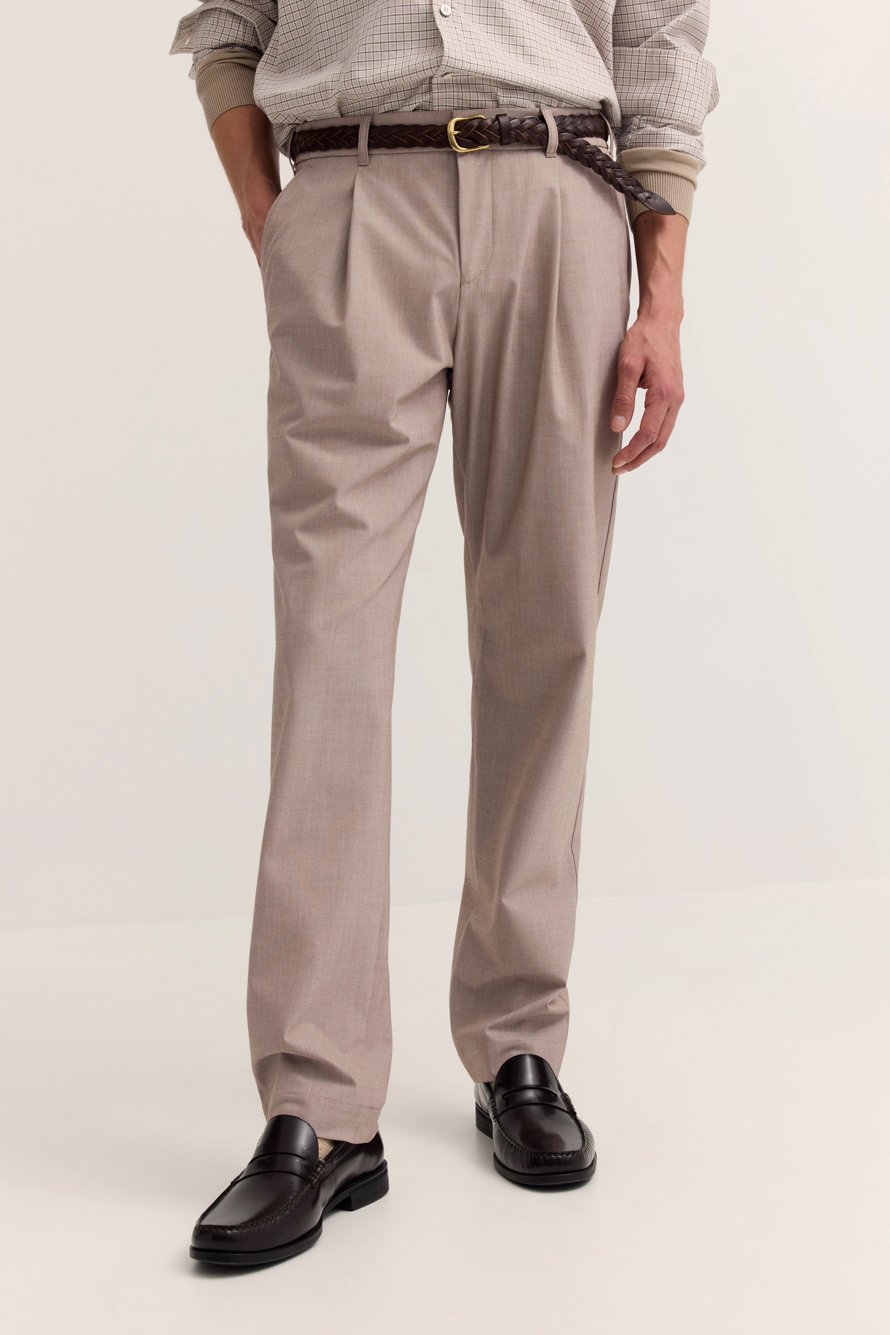 Beige Chino-Hose von bugatti, kombiniert mit braunem Gürtel und schwarzen Loafers, legeres Modelbild.