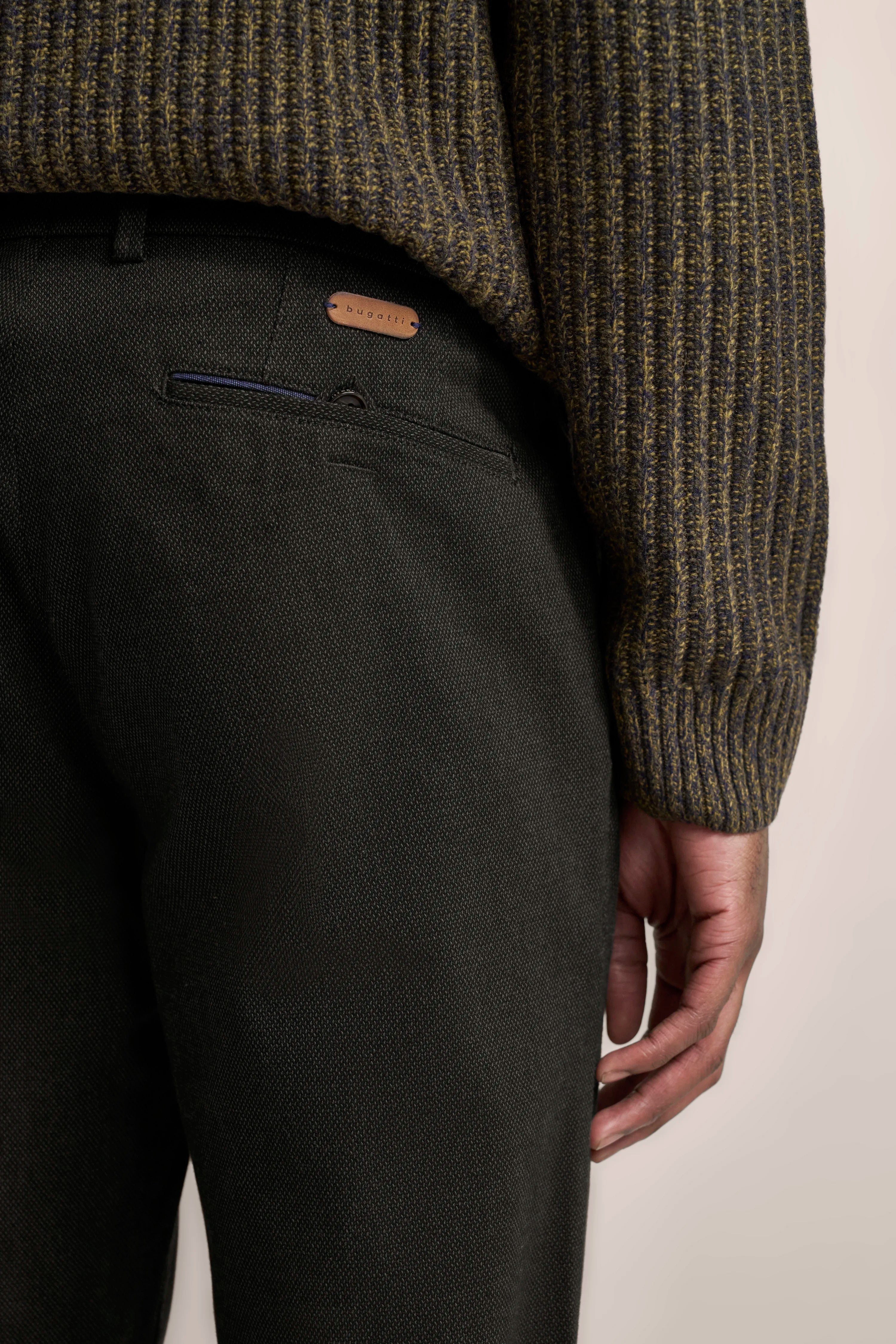 Grüner Strickpullover und dunkle Hose von bugatti, Detailaufnahme, legerer Stil.